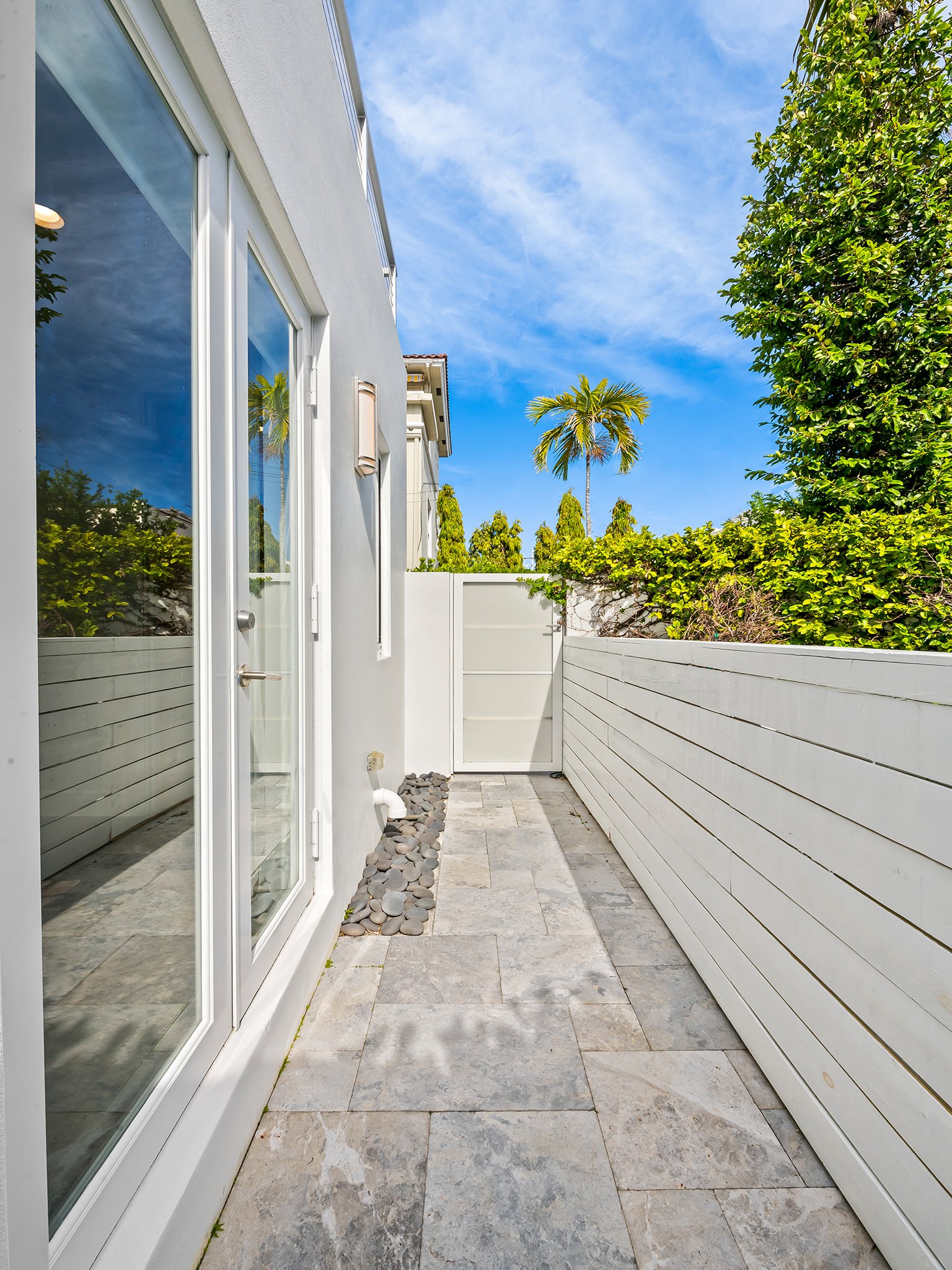 Private side patio with palm tree views — Sun Haven Collection luxury vacation rental outdoor space.