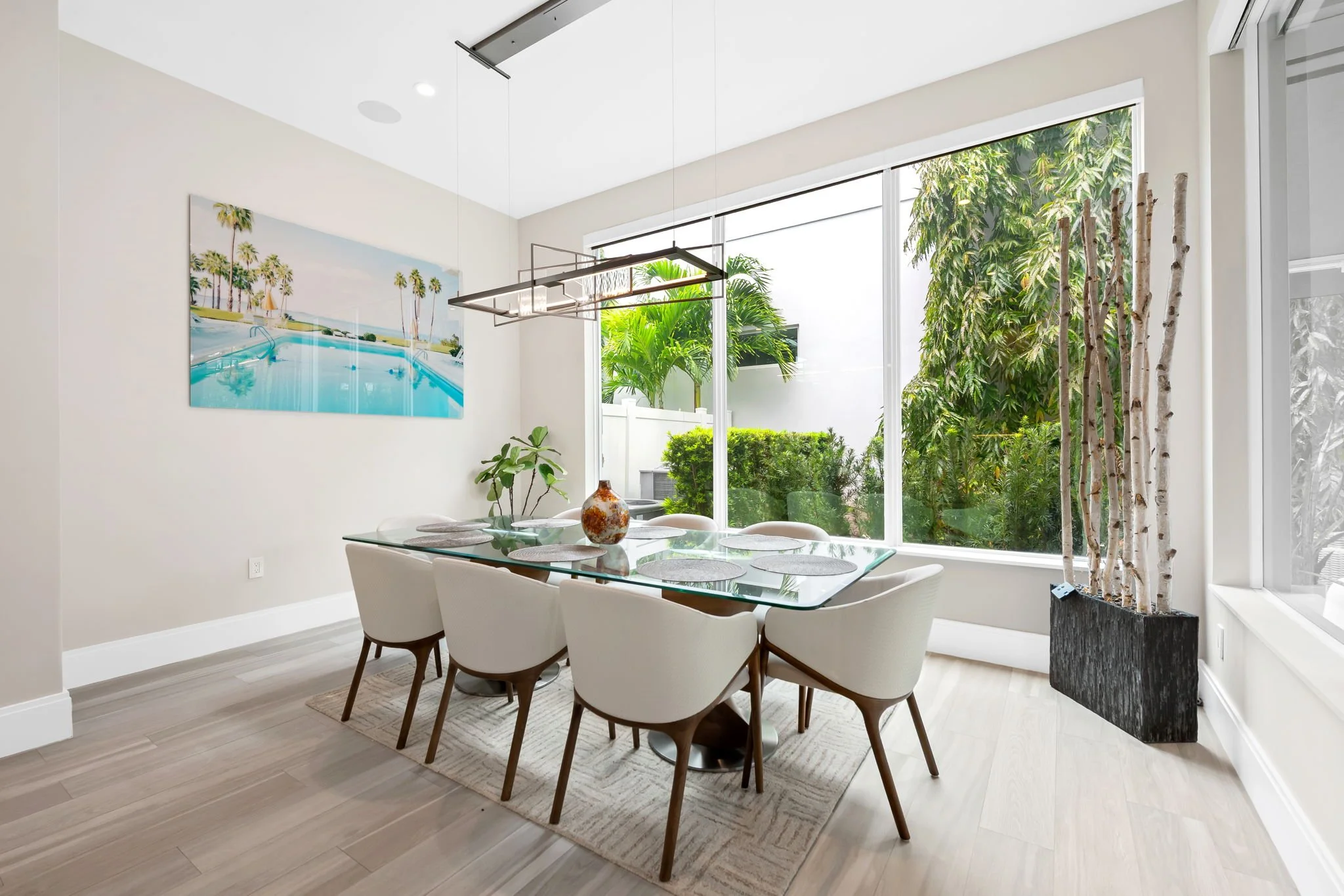 Elegant dining area with tropical art and greenery views — Sun Haven Collection luxury vacation rental.