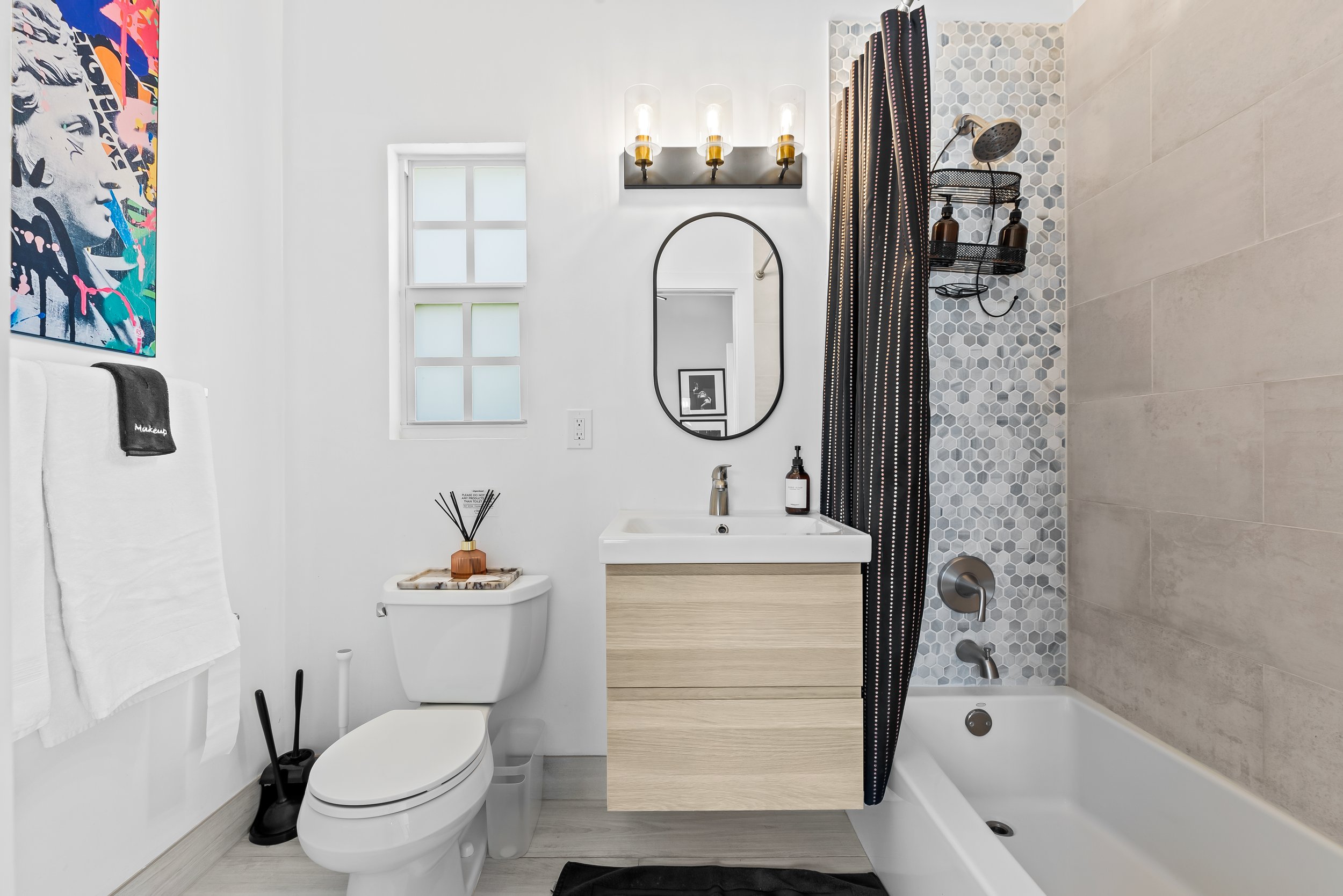 Modern bathroom with hexagonal tile shower and curated amenities — luxury vacation home, Sun Haven Collection.