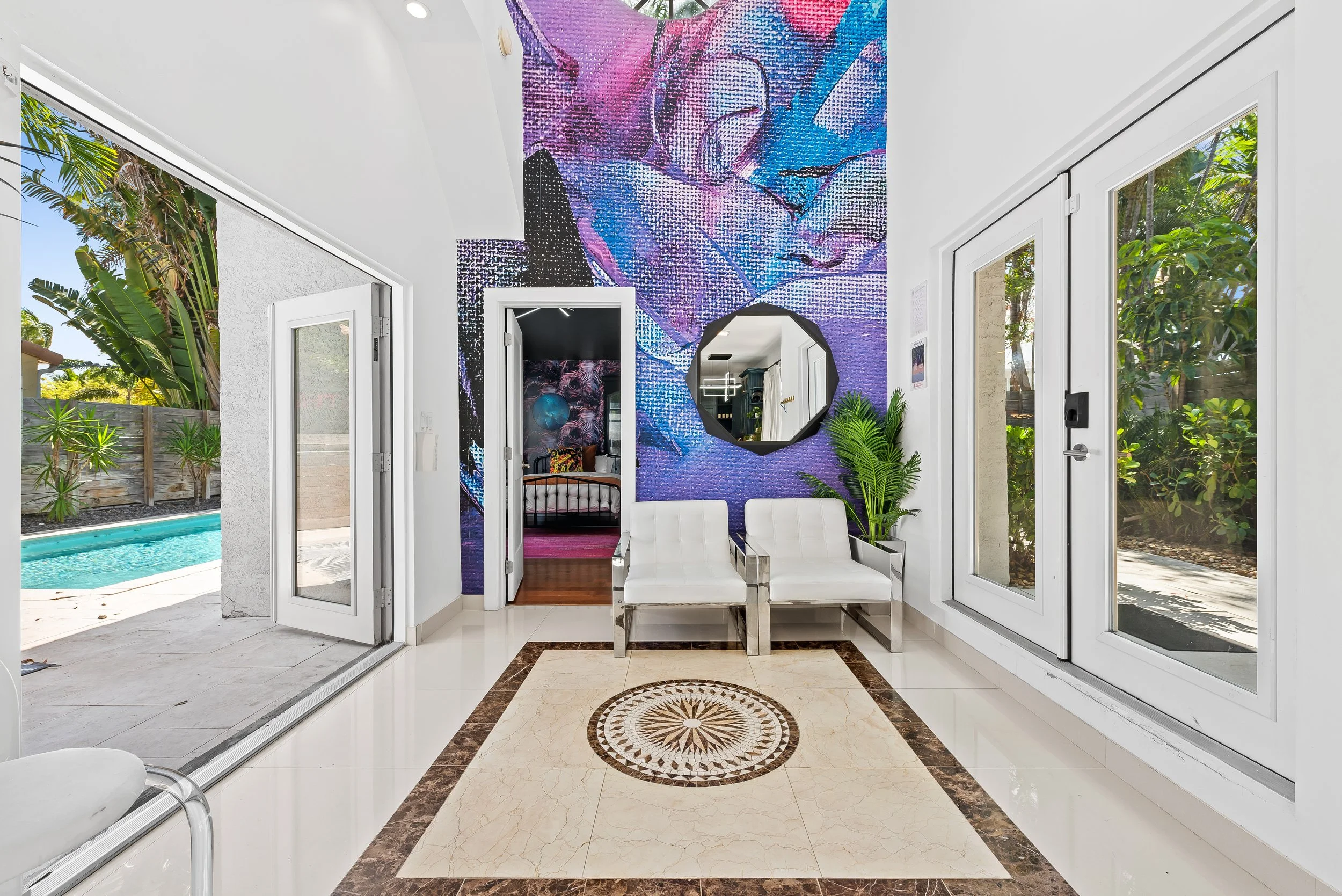 Vibrant abstract mural and poolside entrance — art-inspired luxury vacation rental by Sun Haven Collection.