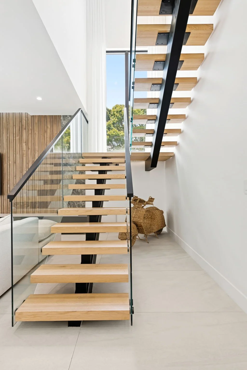 Architectural staircase with glass railing and natural light — luxury vacation rental by Sun Haven Collection.