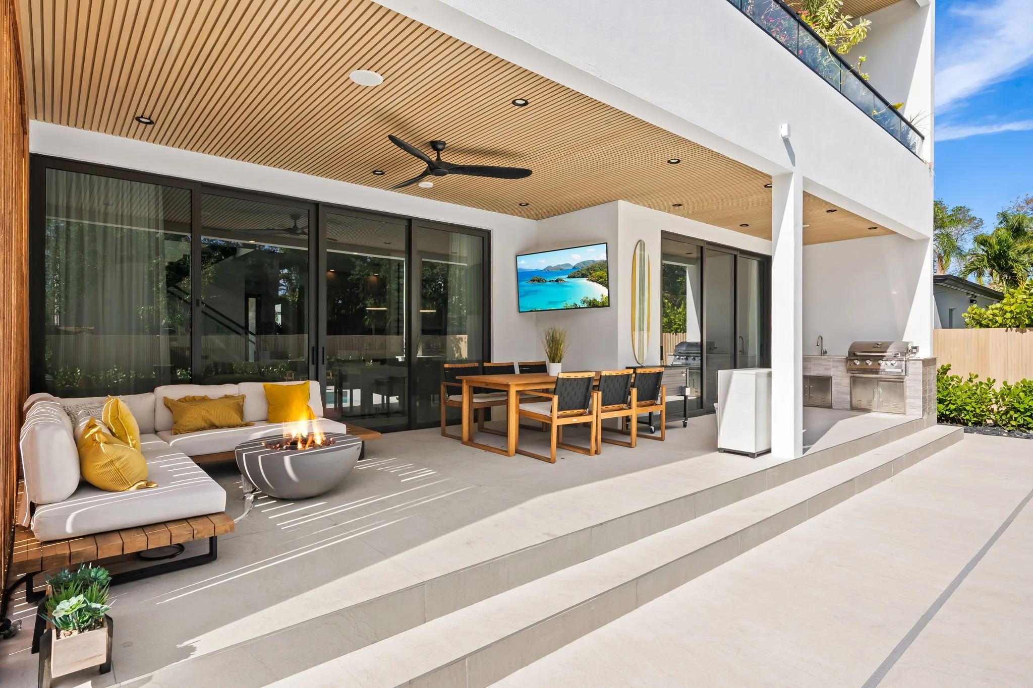 Outdoor living area with fireplace, TV, and mountain views — luxury vacation home by Sun Haven Collection.