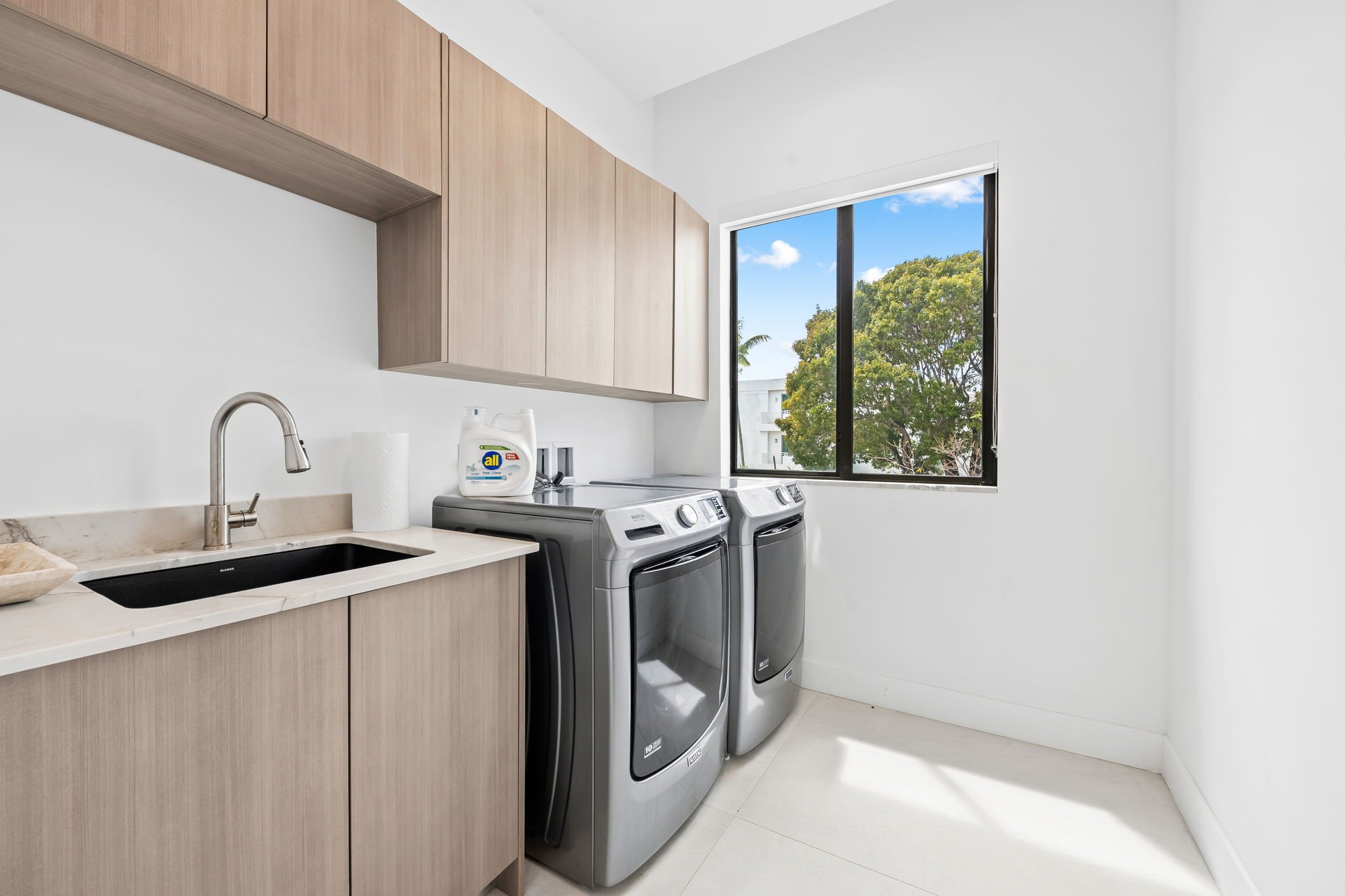 Full laundry room with modern appliances and wooden cabinetry — Sun Haven Collection luxury vacation home.