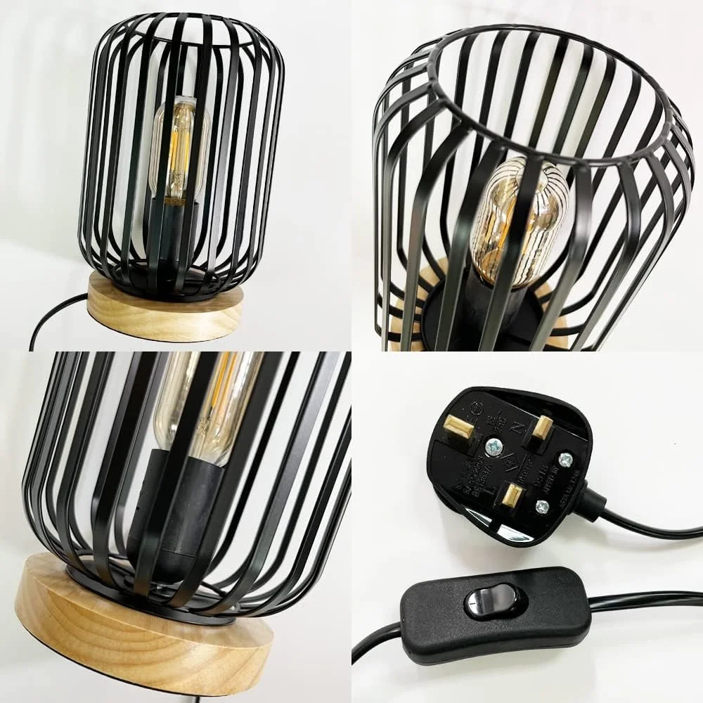 A black metal cage table lamp with a wooden base and an Edison-style filament light bulb inside, with a power cord and switch