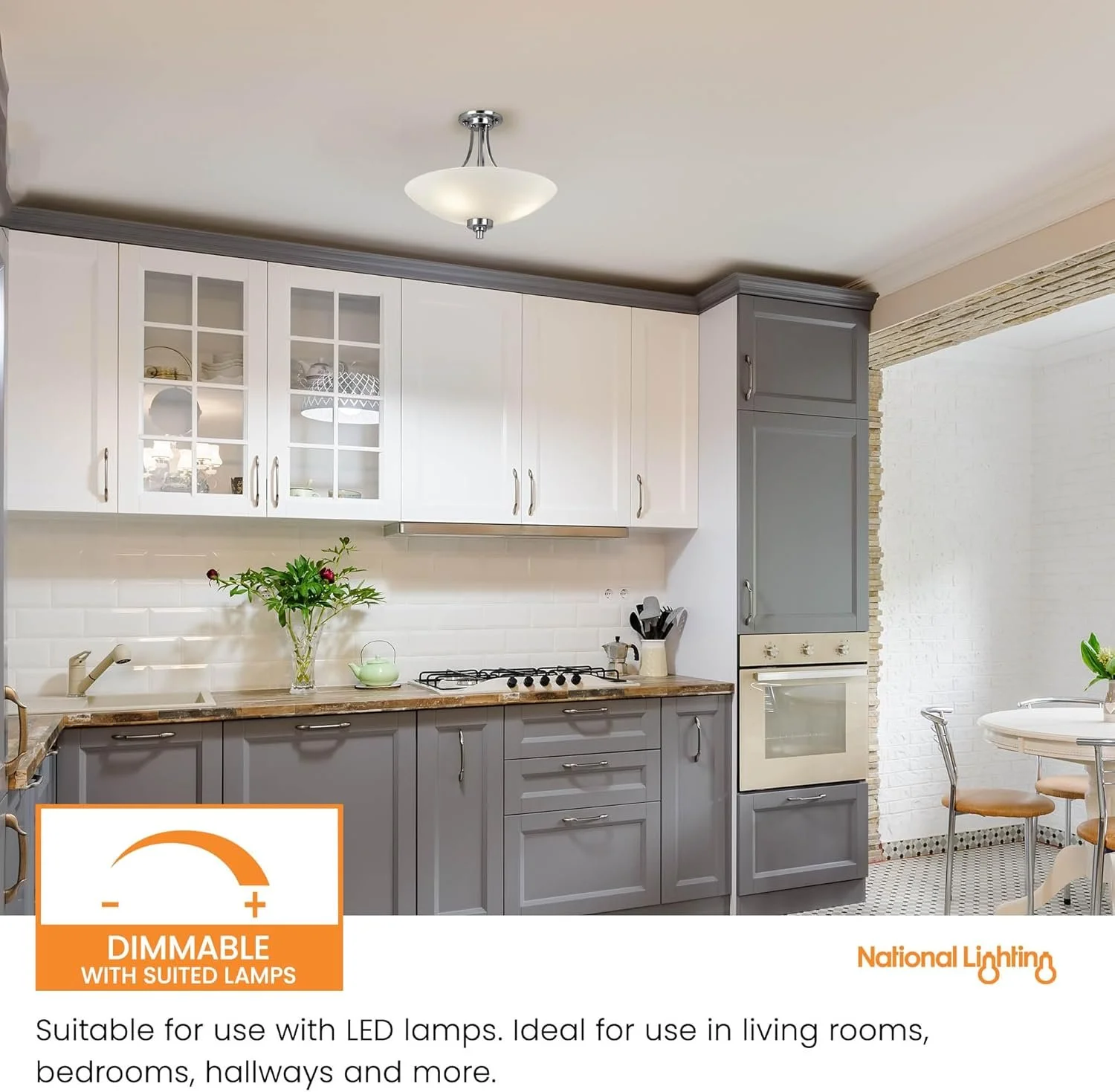 Kitchen with white and gray cabinets, a wooden countertop, a gas stove, a vase with flowers, and a dining table with chairs, lit by a ceiling light.