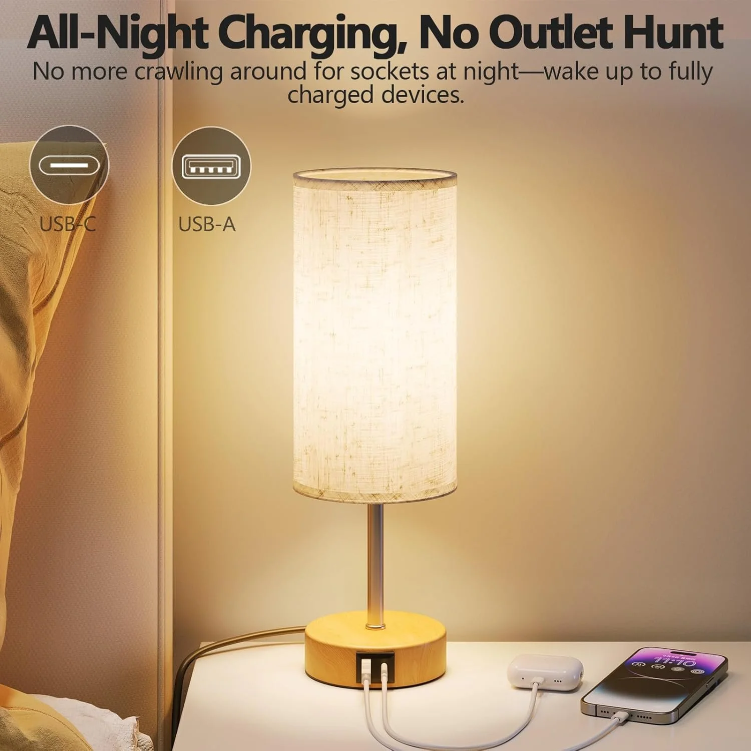 A bedside table with a lamp charging two devices—a white wireless earbuds case and a smartphone—using USB-C and USB-A ports built into the lamp's wooden base, with labels indicating the charging ports.