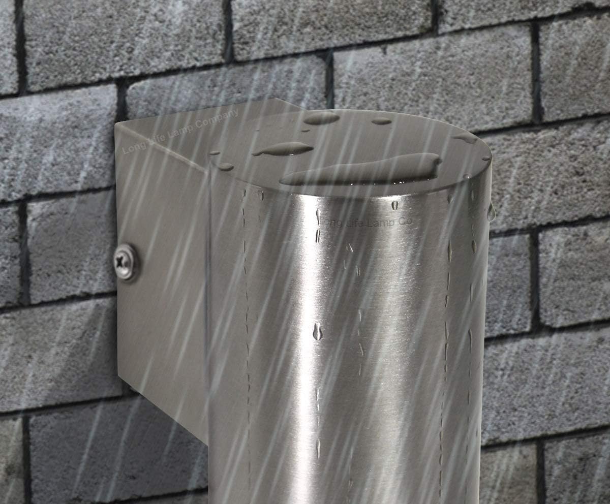 A metallic outdoor light fixture mounted on a brick wall, with rain falling on it.