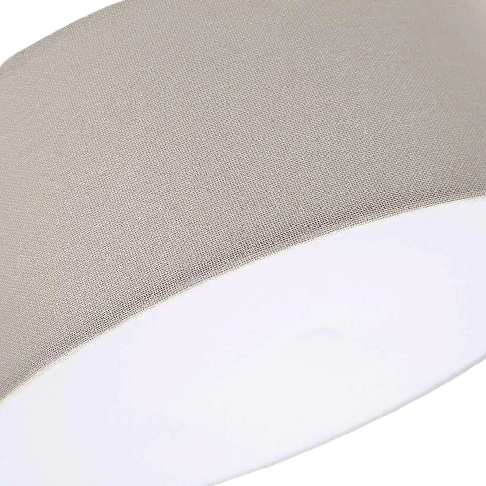 Close-up of a modern ceiling light fixture with a round, white diffuser and textured metallic rim.