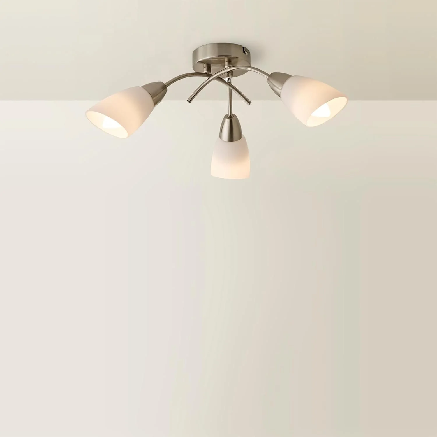 Modern ceiling light fixture with three lampshades, mounted on a white ceiling.