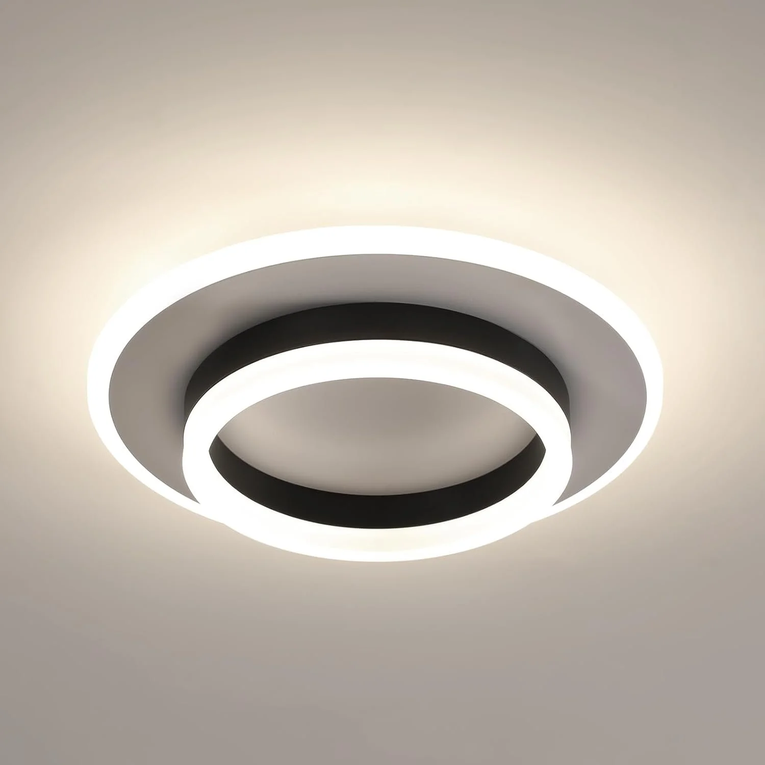 Modern ceiling light fixture with concentric rings emitting white light.