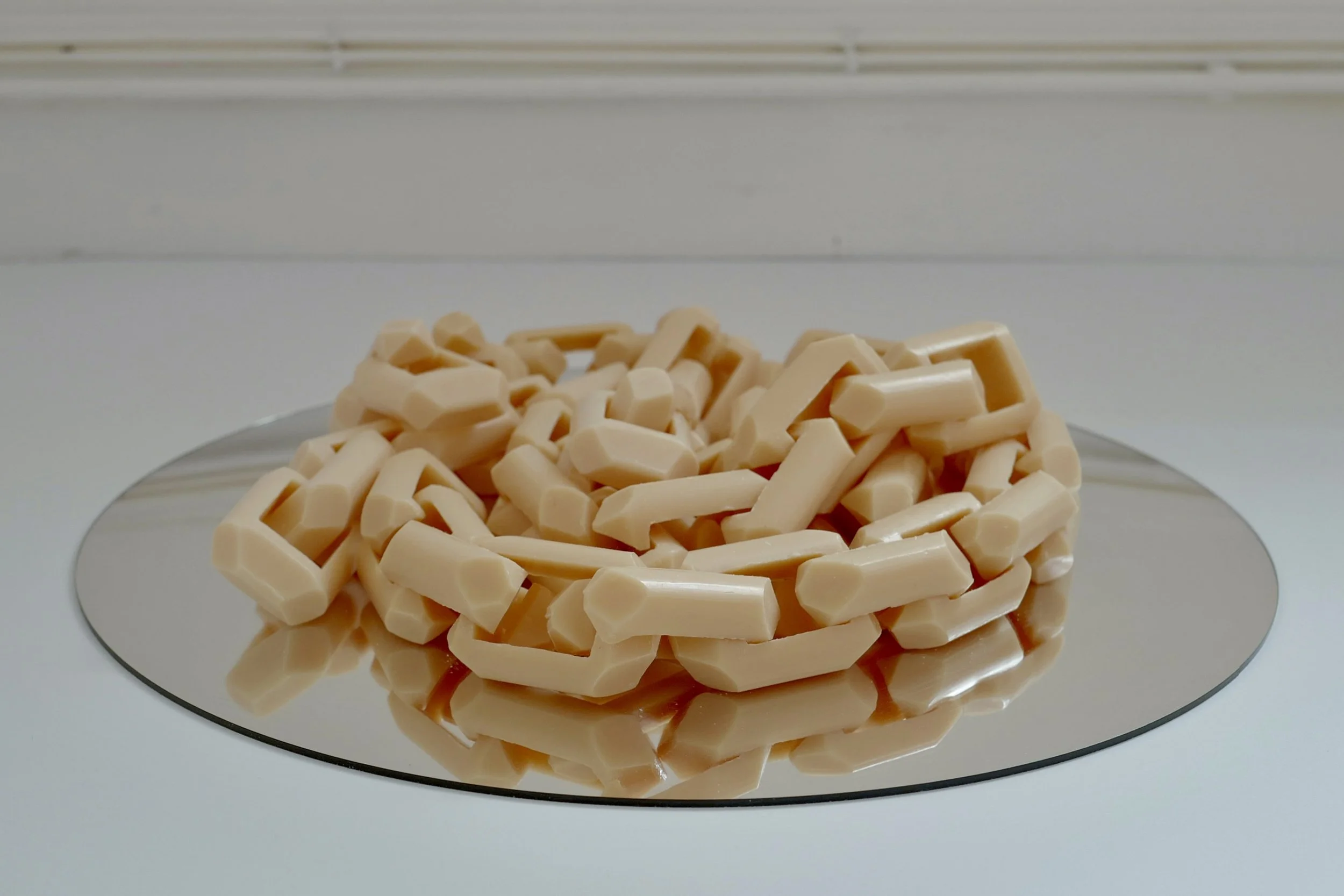 An image of Rinse, Repeat shot almost parallel to the artwork, showing the height of the piled soap links and pooling chain.
