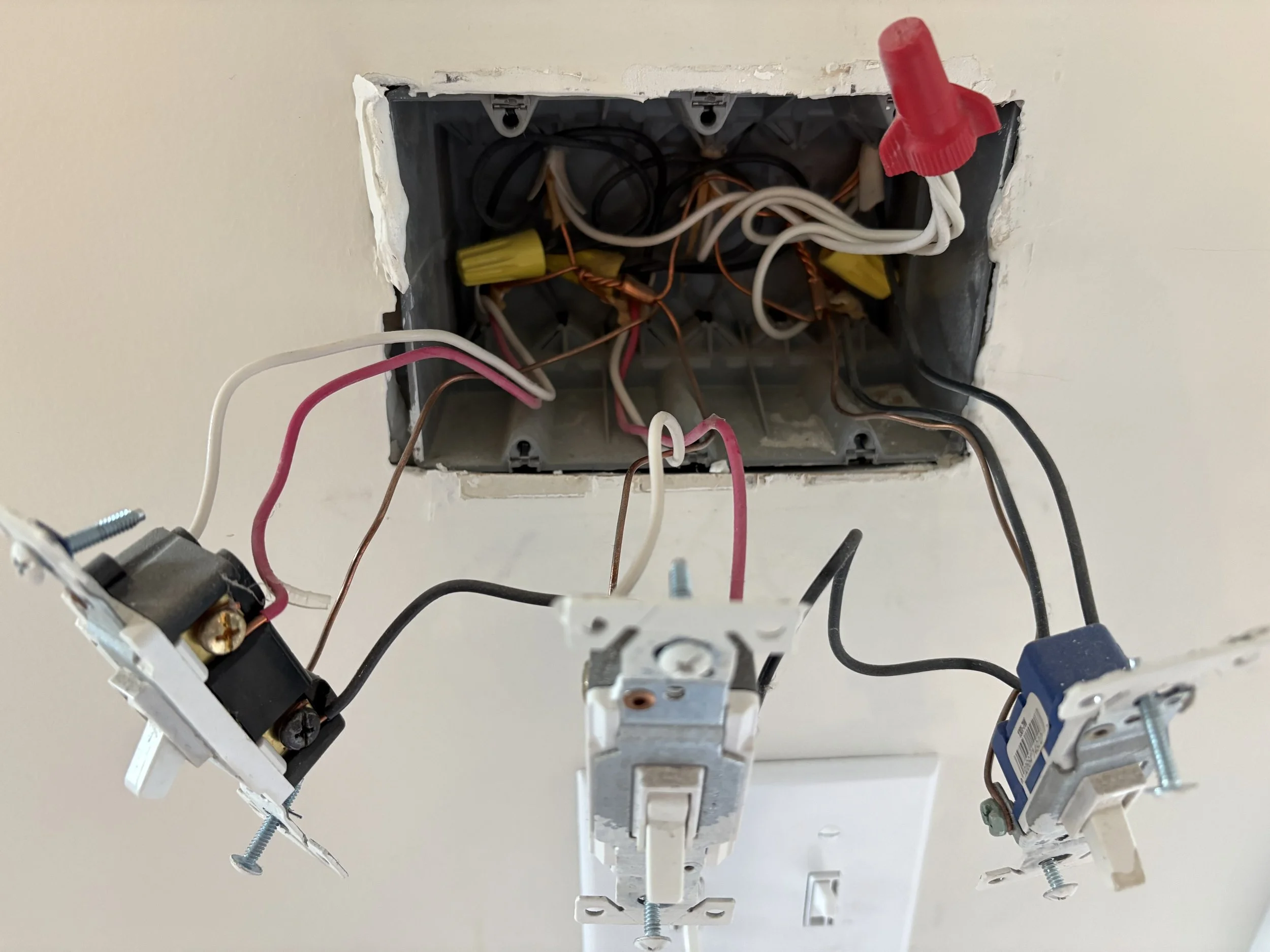 Electrical wiring and switch components inside an open ceiling electrical box