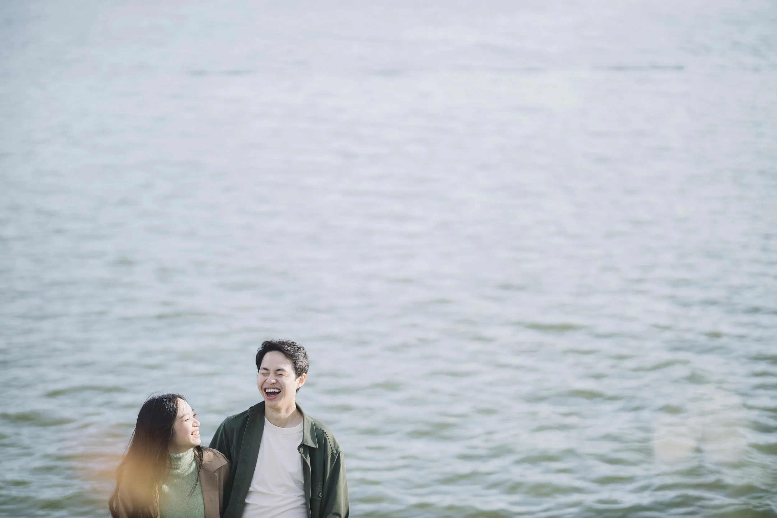 Smiling couple enjoying time together by the water, illustrating healthy relationship connection