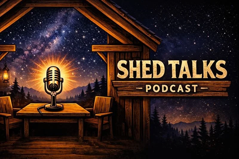 A rustic outdoor podcast setup with a microphone on a wooden table, surrounded by chairs, under a starry night sky with the Milky Way, trees, mountains, and a wooden structure with a sign that reads 'Shed Talks Podcast'.