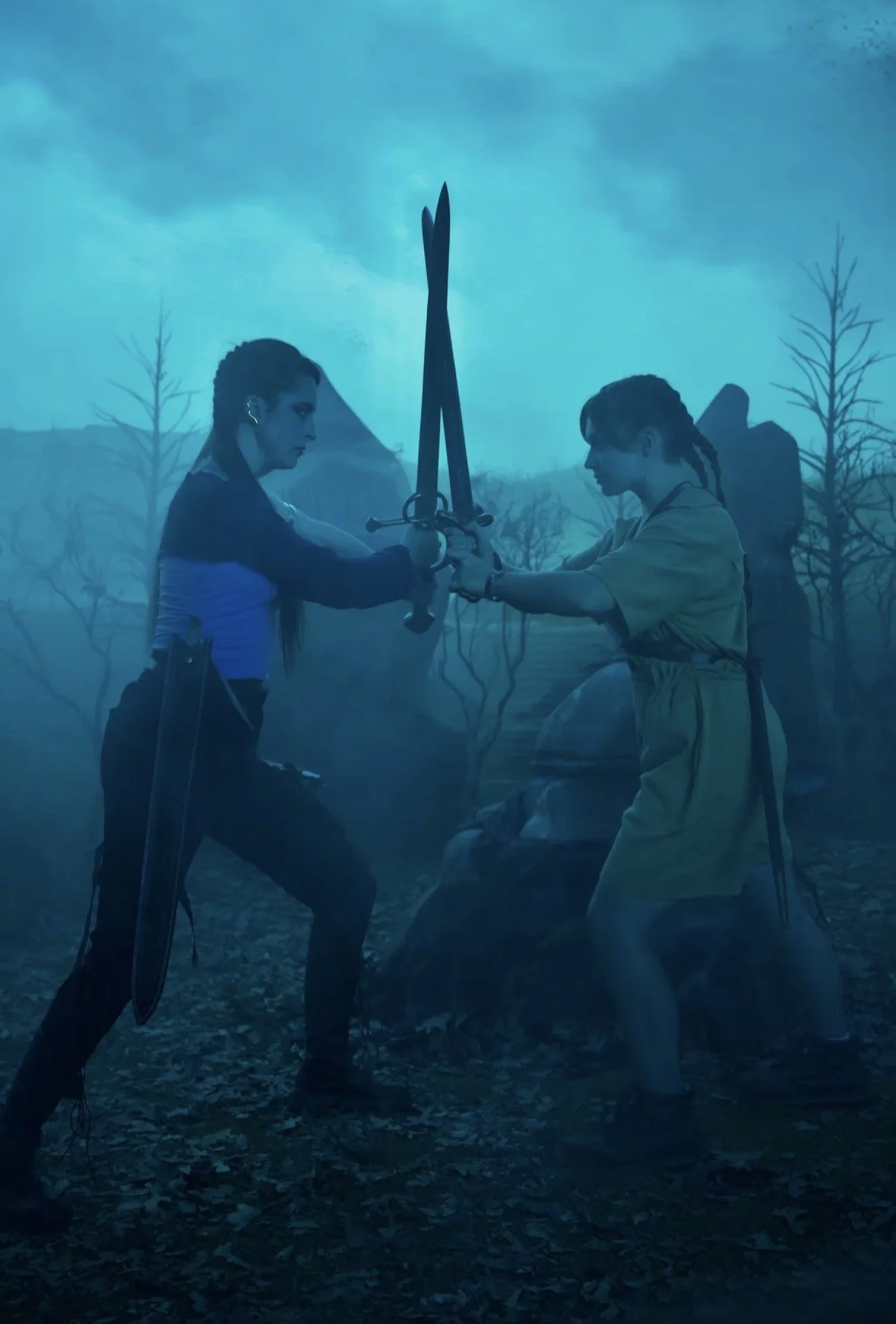 Two women fighting with swords in a foggy, forested landscape.