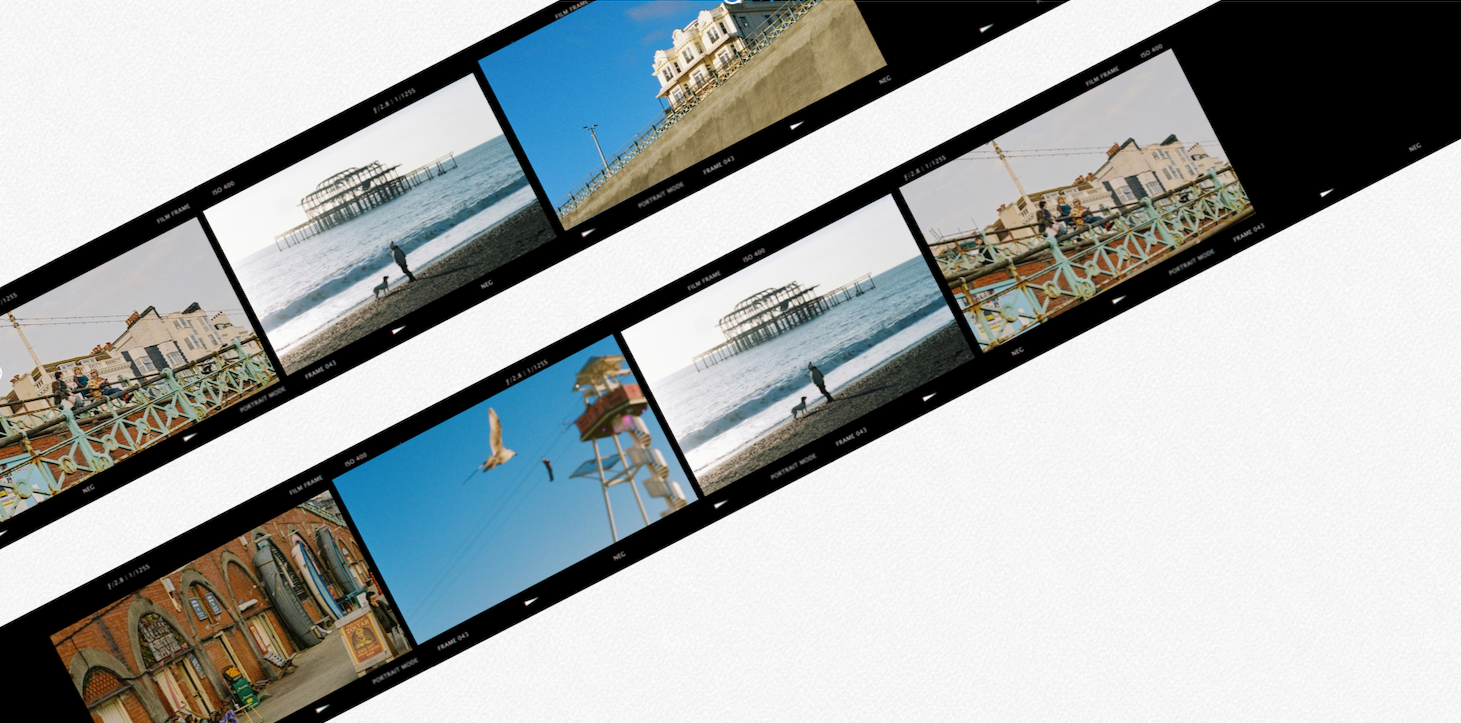 A film strip showing various seaside scenes, including a pier, a lifeguard tower, seagulls flying, and a row of storefronts, with blue sky in the background.