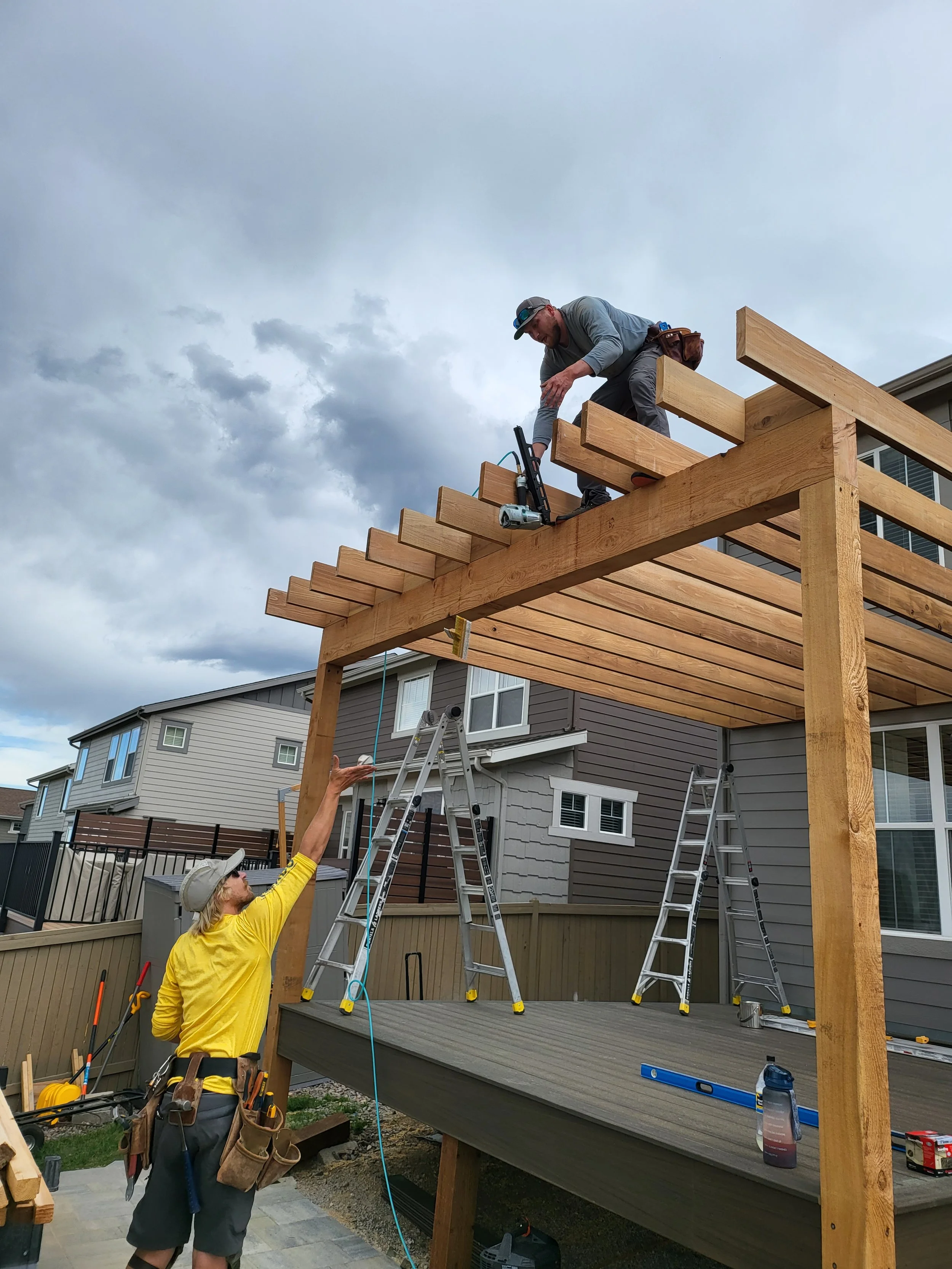 Best pergola Builders in Colorado.  Working on a Deck with a pergola over top