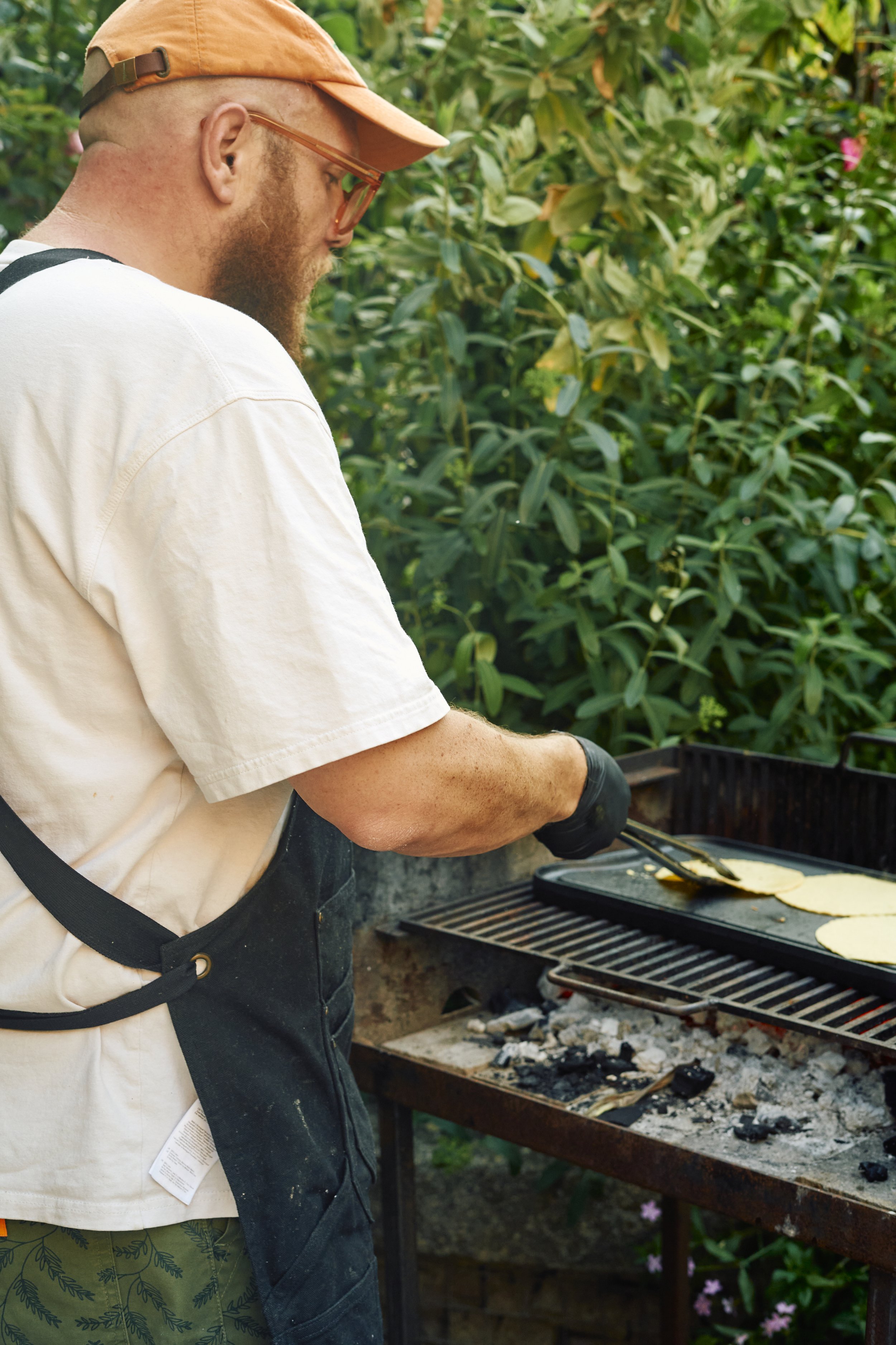 Man grilling tortillas on an outdoor barbecue
