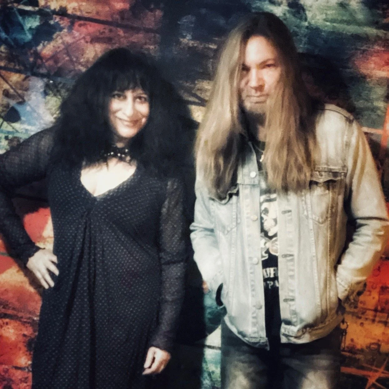 Singer Tracie Law with long blond hair, and violinist Pam Chowhan with black hair, both from Symphony of Pain, posing together against a colorful, abstract background.