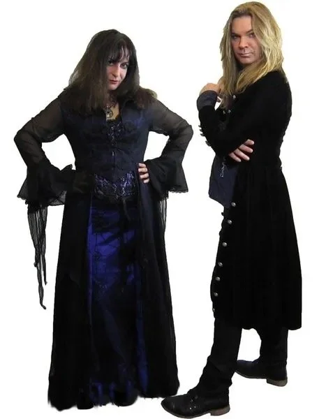Tracie Law and Pam Chowhan, both members of the band Symphony of Pain, with long hair, wearing dark, gothic-style clothing, standing against a white background.