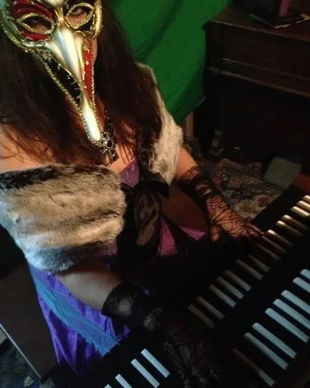 Pam Chowhan, keyboardist from band Symphony of Pain, wearing a decorative mask playing a harpsichord as part of the video shoot for the song, 'Kiss the Bride' from the album Hydeology.
