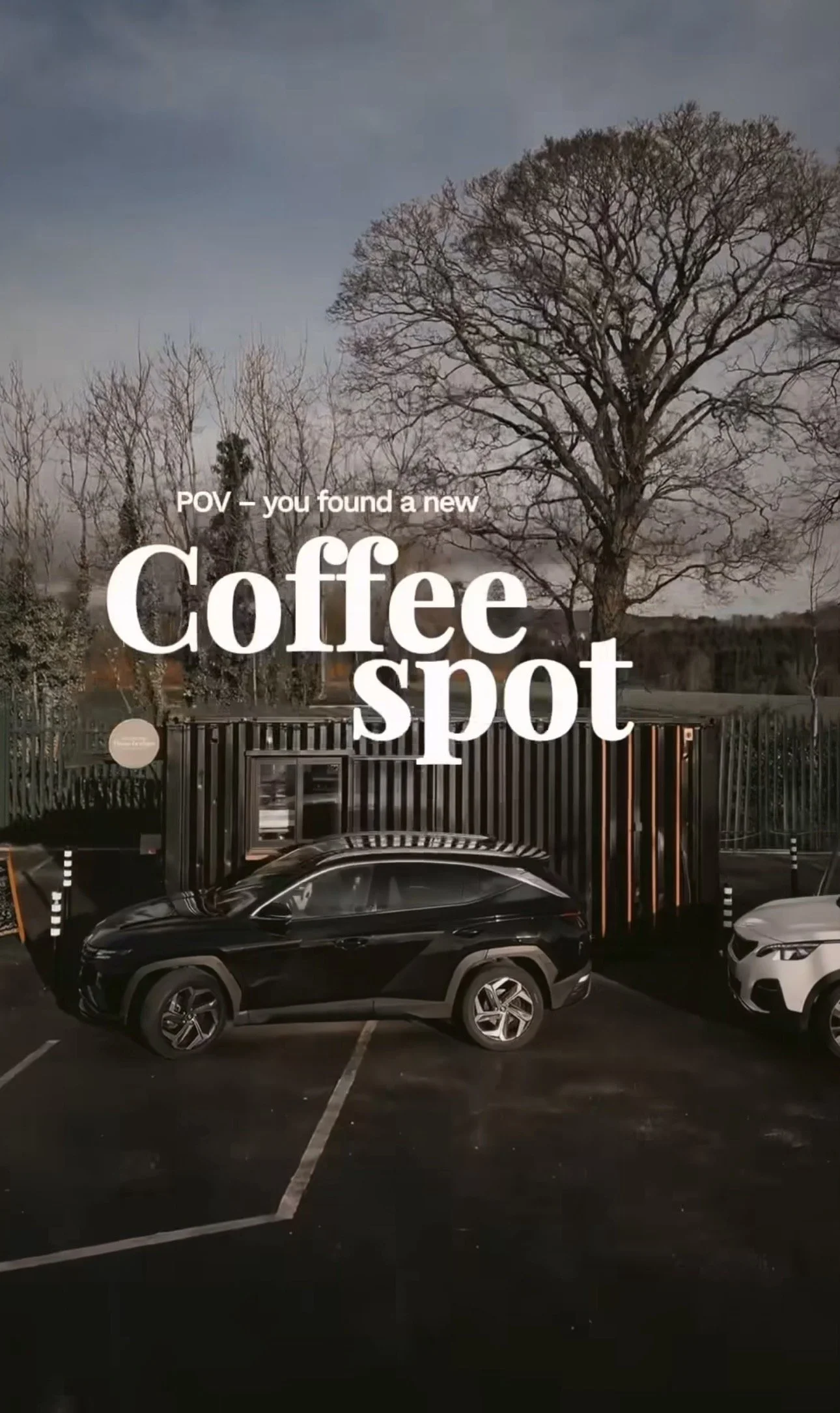 Empty parking lot in front of a coffee shop with a large tree in the background and large text overlay that reads 'POV — you found a new Coffee spot'.