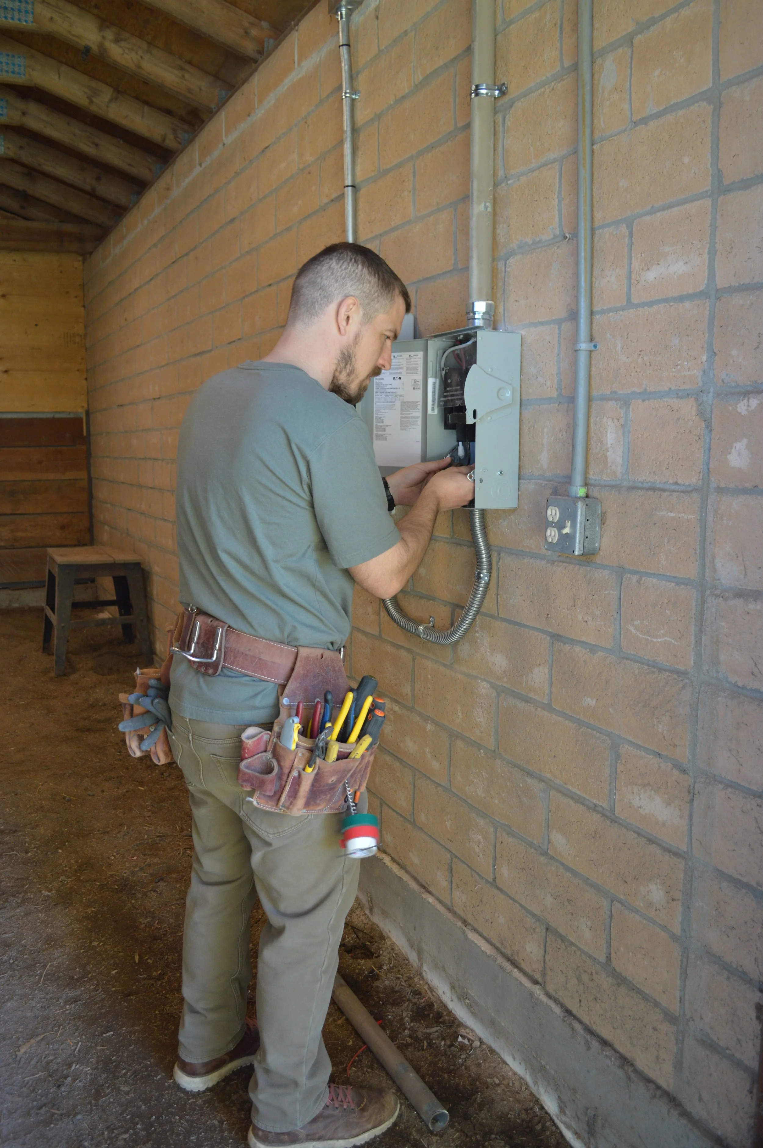 Collins Electric electrician working at a panel with conduit, the kind of sequenced work Windsor, CA builds need.