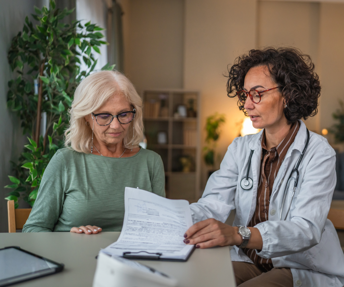 A female doctor reviewing a Speak Easy GYN worksheet with her female patient