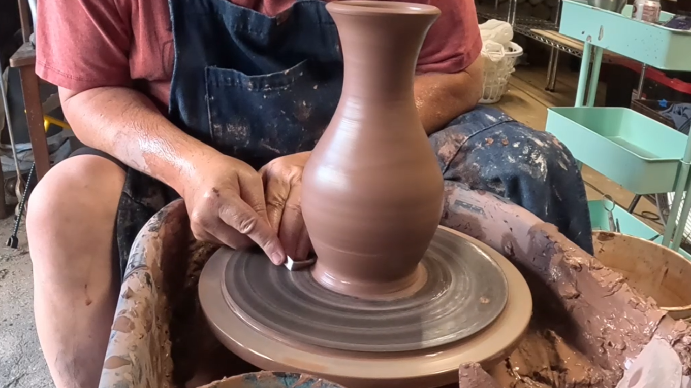 Chris throwing the Starry Night Vase on the pottery wheel, shaping the elegant hourglass form before carving the signature spiral pattern