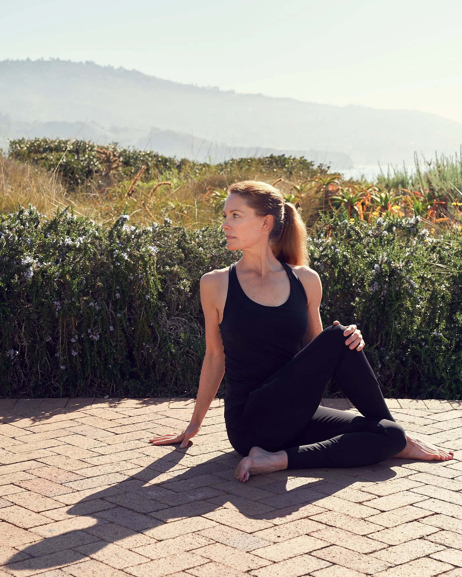 Dana Wyss Health & Movement Coach Twisting outdoors near ocean