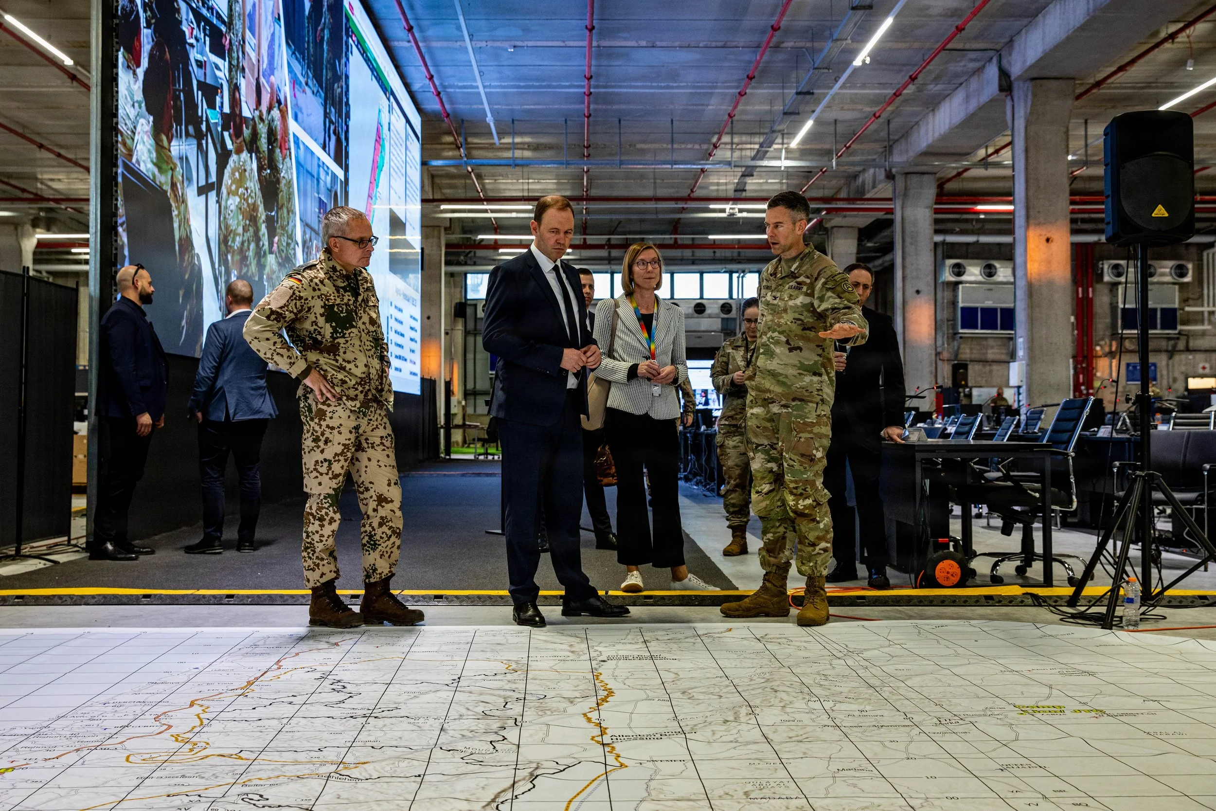 KIRYAT GAT, Israel -- U.S. Army Col. Stuart Peebles shows Nils Hilmer, German State Secretary at the Federal Ministry of Defence, an area map inside the Civil-Military Coordination Center (CMCC), Dec. 17, 2025. Germany is one of more than 60 nations 