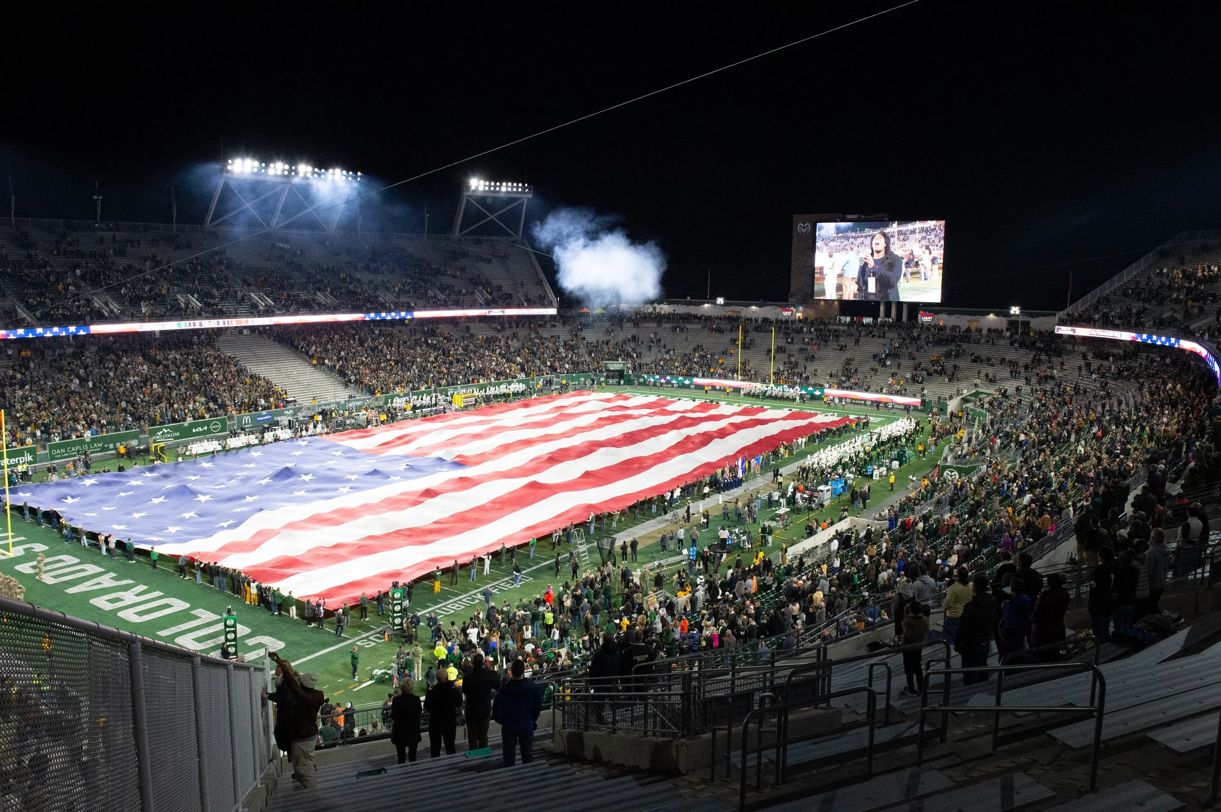 American flag being unfurled at Colorado State University's Canvas Stadium before a home-football game, Nov. 15, 2024.