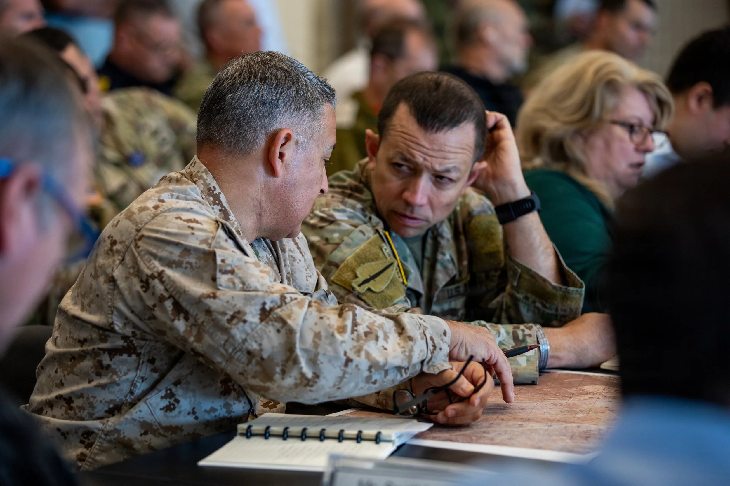 U.S. service members discuss operations after a meeting inside the Civil-Military Coordination Center on Nov. 1, 2025, in Israel. The CMCC brings together representatives from partner nations, non-governmental organizations, international institution