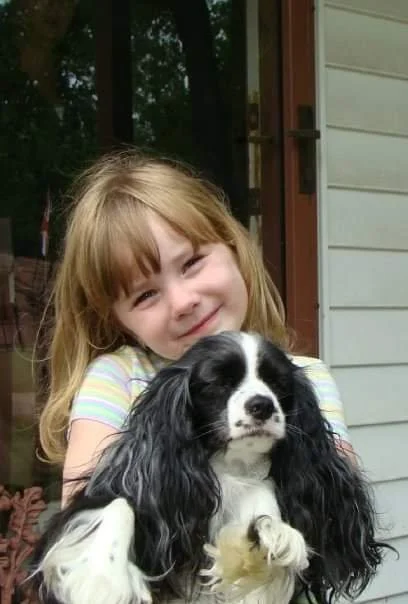Image of Kathryn and her childhood dog, Dusty, outside of her childhood home in St. Louis.