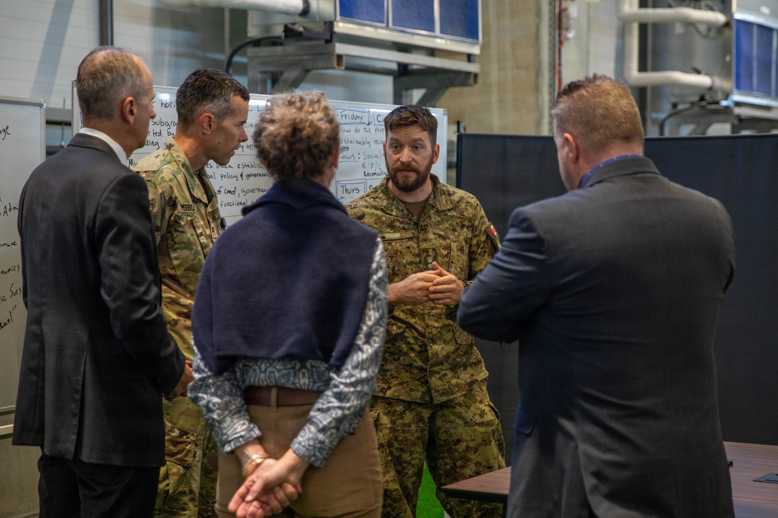 Canadian Armed Forces Lt. Col. Jonathan Evans speaks with U.S. Army Col. Stuart Peebles, and representatives from non-government organizations (NGO) after a meeting inside the Civil-Military Coordination Center (CMCC) on Oct. 27, 2025, in Israel. (U.
