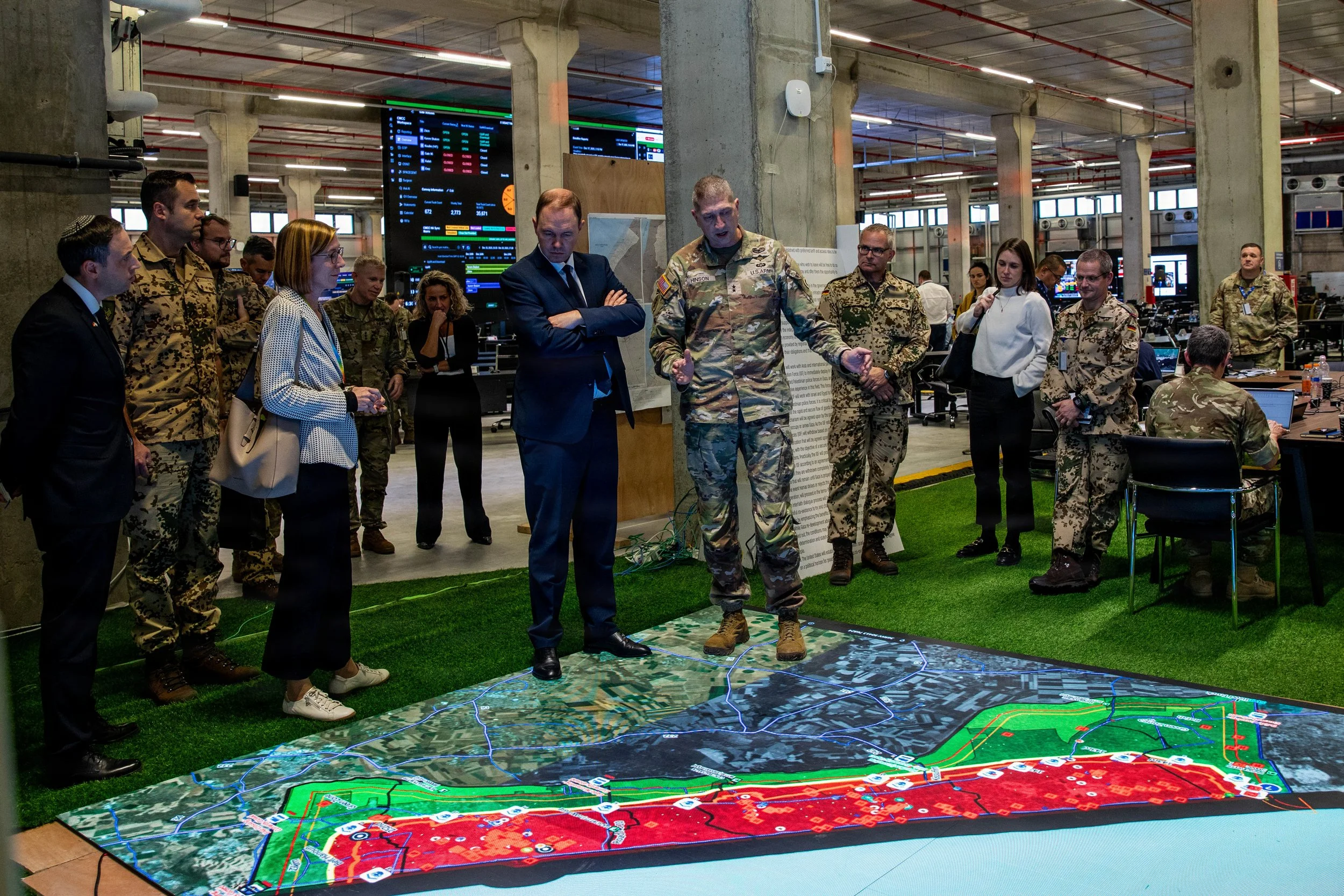 KIRYAT GAT, Israel -- U.S. Army Maj. Gen. Brad Hinson speaks with Nils Hilmer, German State Secretary at the Federal Ministry of Defence, about the humanitarian assistance efforts coordinated by the Civil-Military Coordination Center (CMCC), Dec. 17,