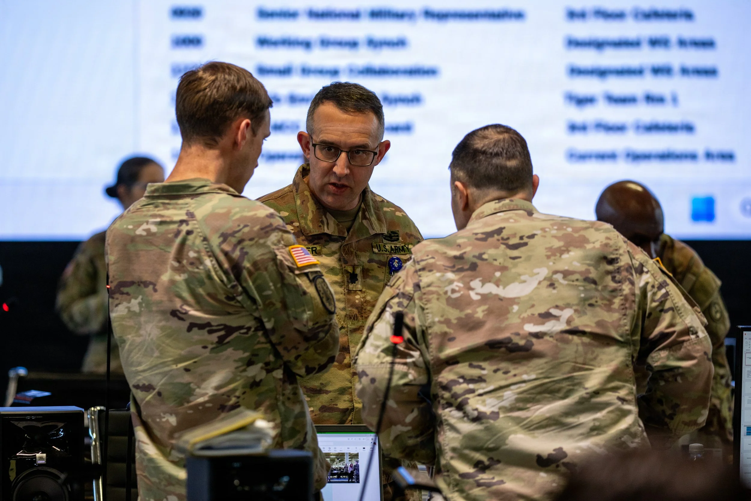 U.S. Army Lt. Col. Michael Fletcher discusses daily operations with the Civil-Military Coordination Center (CMCC) Current Operations Officer-In-Charge, Col. John Chavous, at the CMCC, Dec. 7, 2025. The CMCC brings together more than 50 nations and or