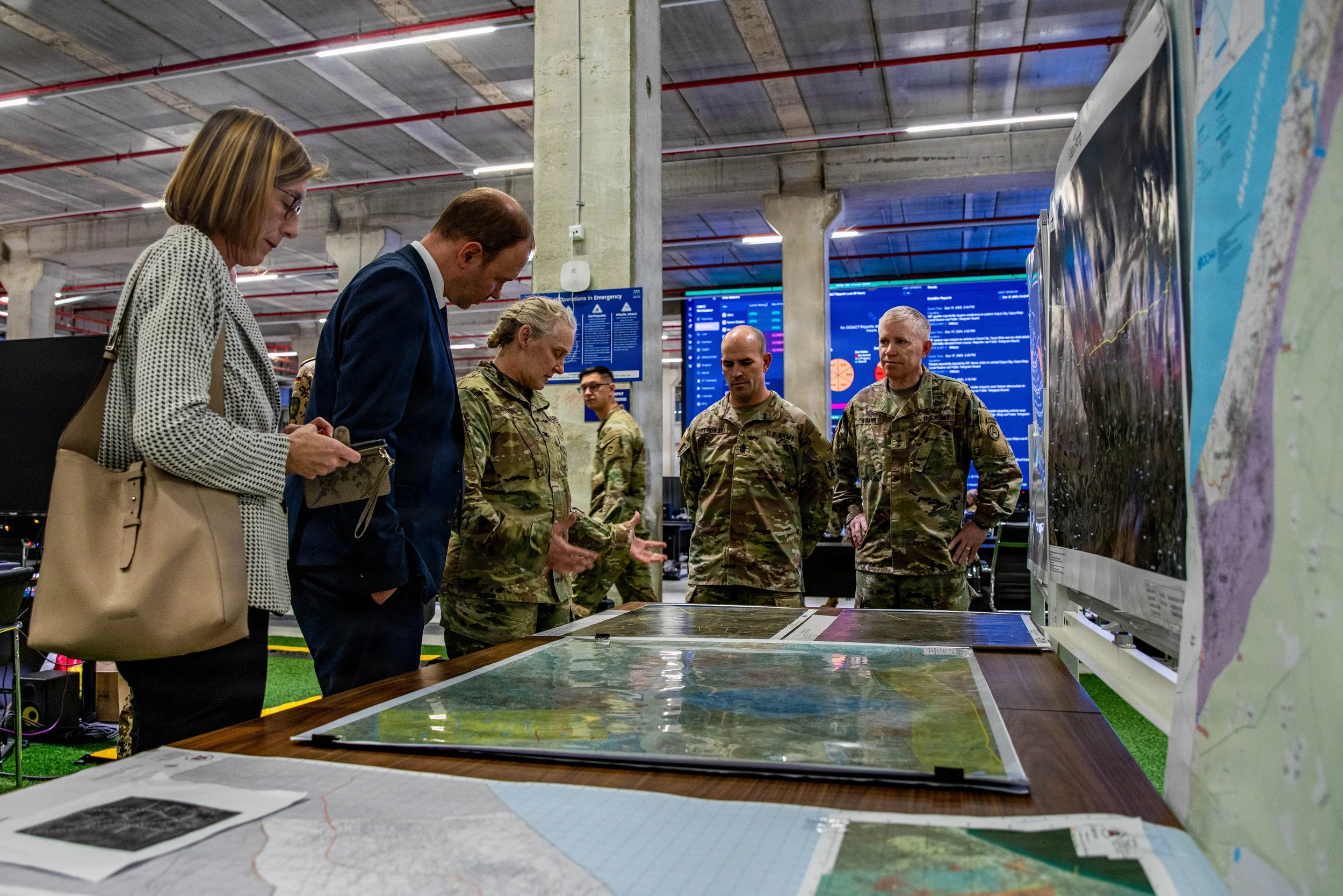 KIRYAT GAT, Israel -- U.S. Army Col. Christina Burton speaks with Nils Hilmer, German State Secretary at the Federal Ministry of Defence, about the Gaza rubble clearing operations coordinated by the Civil-Military Coordination Center (CMCC), Dec. 17,