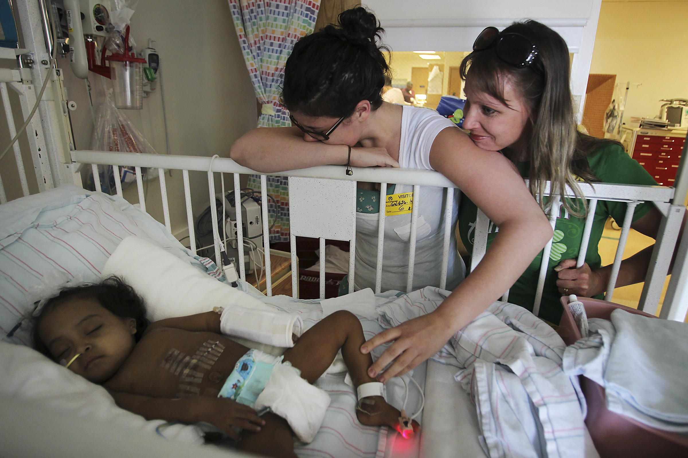 Foster parent Sharon King, on right, and organ donor Brittany Quirk react as they look upon Anna (last name withheld) as she recovers from liver transplant surgery in the Children's Hospital of Los Angeles on July 6, 2011.  Quirk, who donated about 1