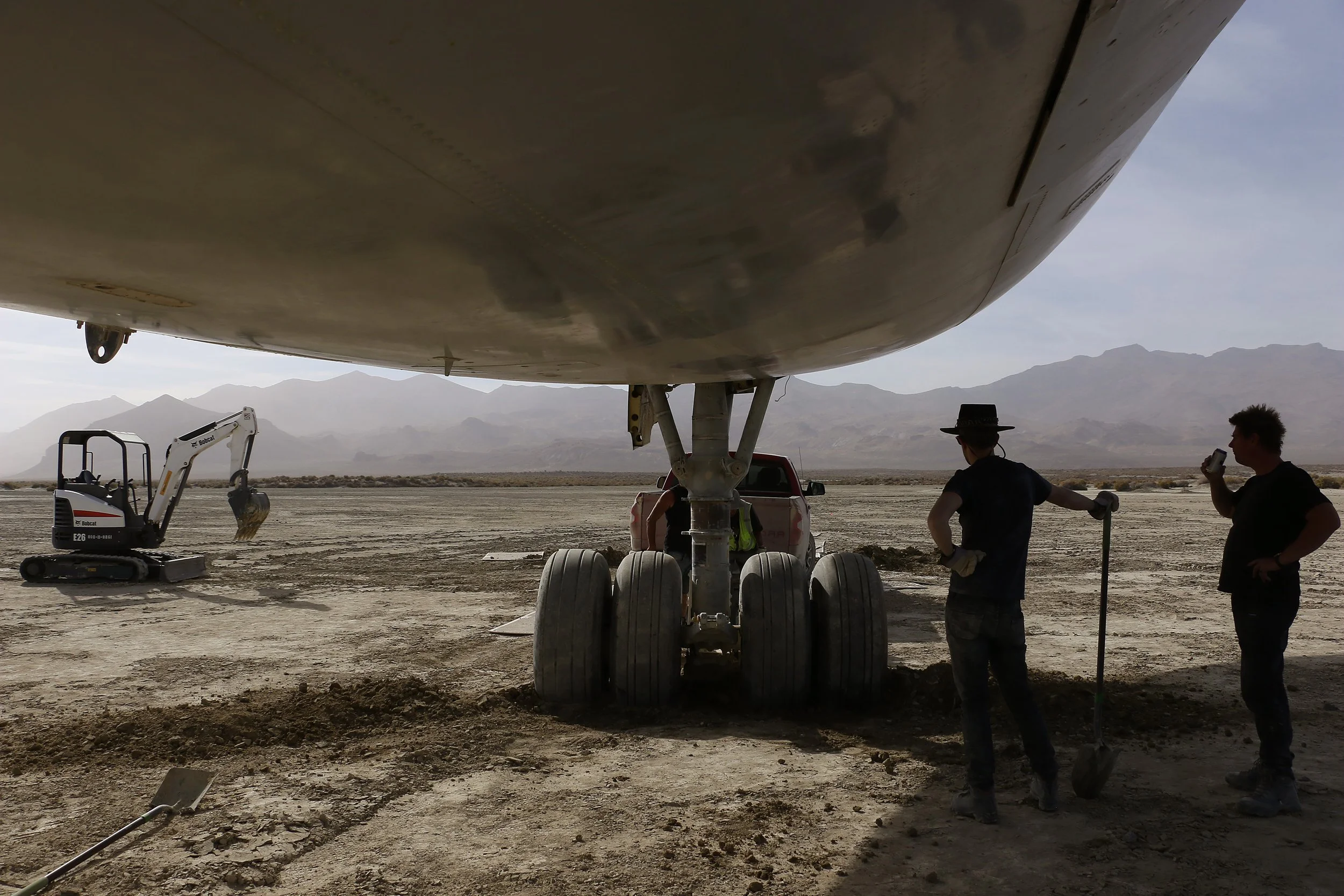 A crew of volunteers work to move a Burning Man art airplane off of the Black Rock Desert playa on Sept. 21, 2018.
