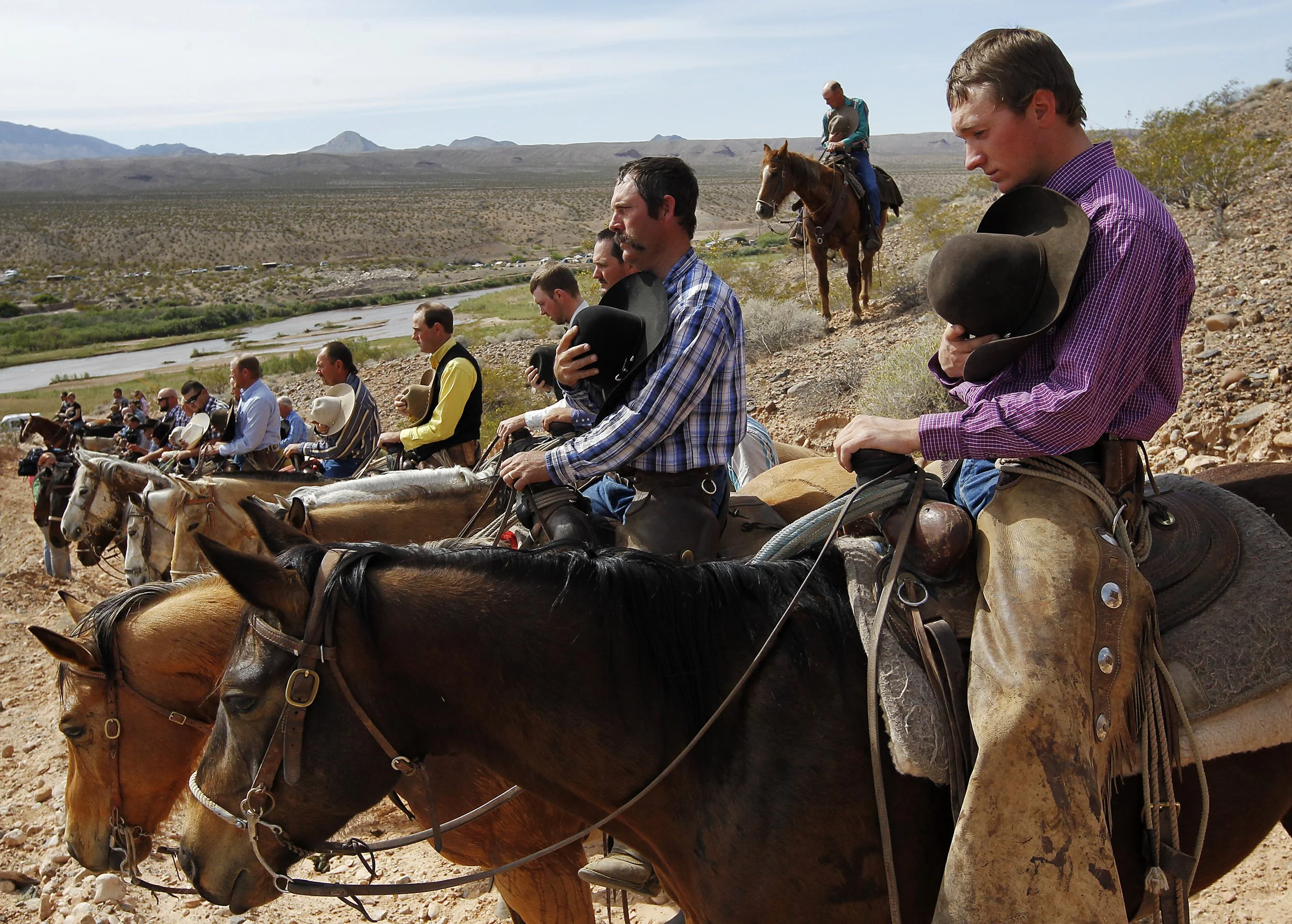 Kholten Gleave, right, of Utah, pauses for the National Anthem outside of Bunkerville while gathering with other supporters of the Bundy family to challenge the BLM with regards to cattle grazing fees on April 12, 2014.