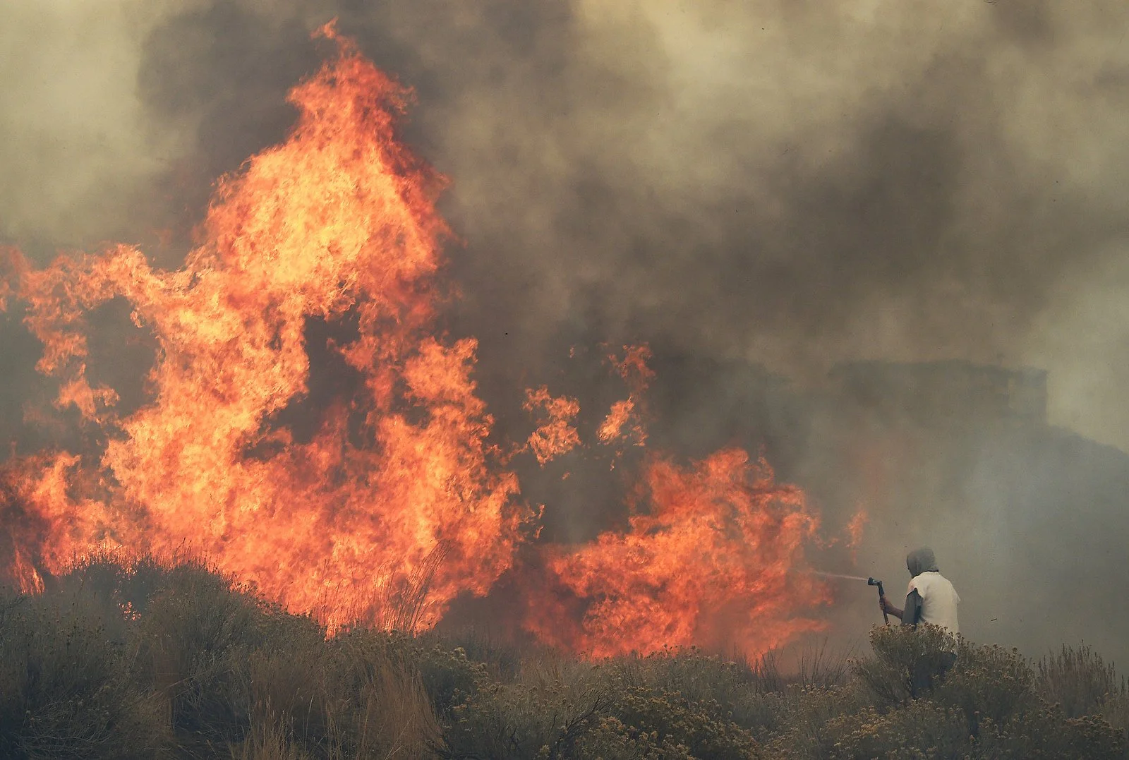 Homeowner Steven Phelps battles the Pinehaven Fire in the Caughlin Ranch area of Reno on Nov. 17, 2020.