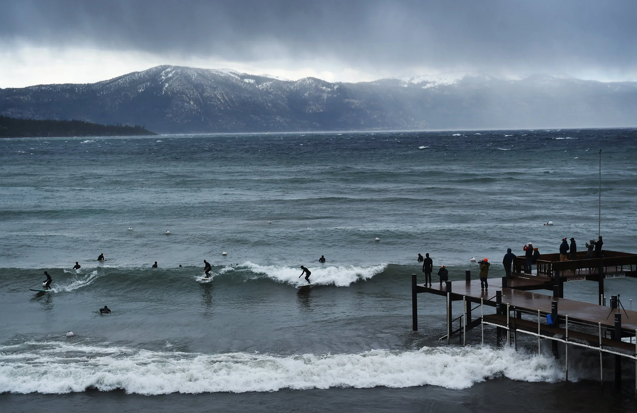 Surfers catch a wave during a stormy day at Lake Tahoe on Dec. 11, 2014. 