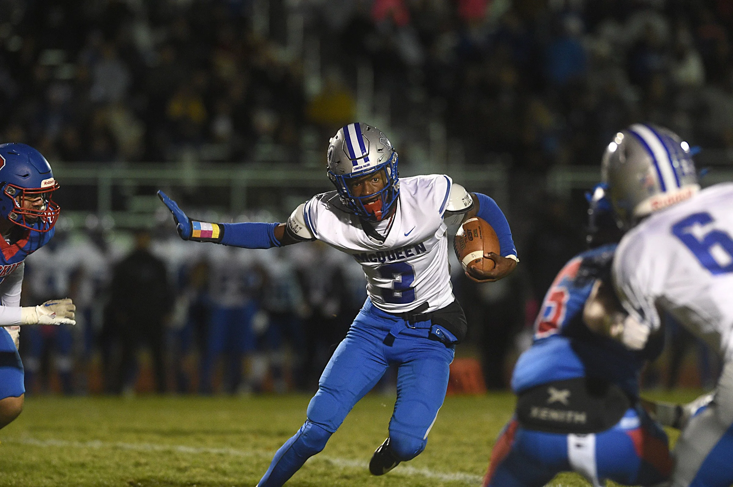 McQueen’s Carl "Tre" LaGrone III looks to run while taking on Reno during their playoff football game at Reno on Oct. 26, 2023.