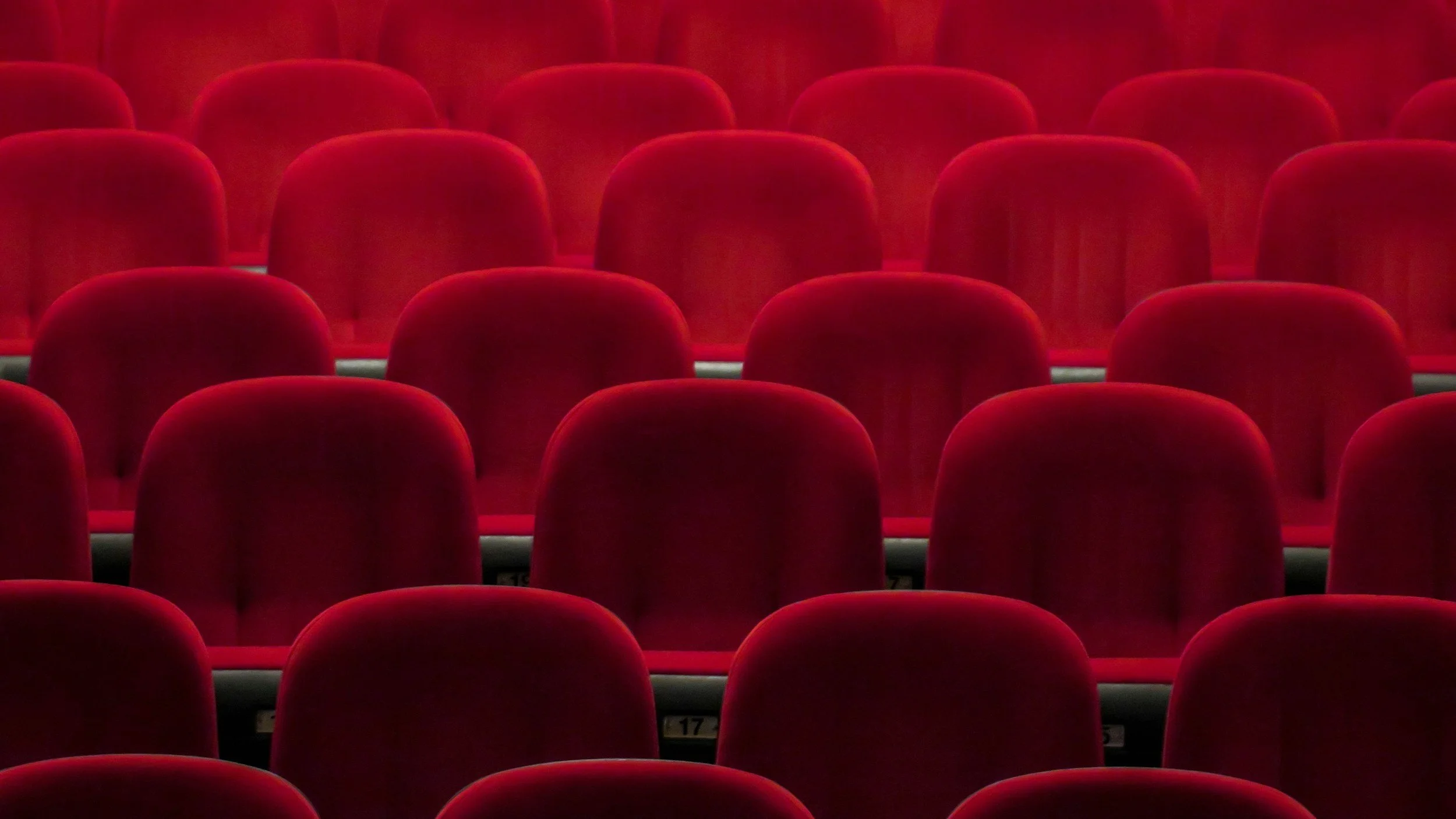Red theater seats in an empty auditorium.