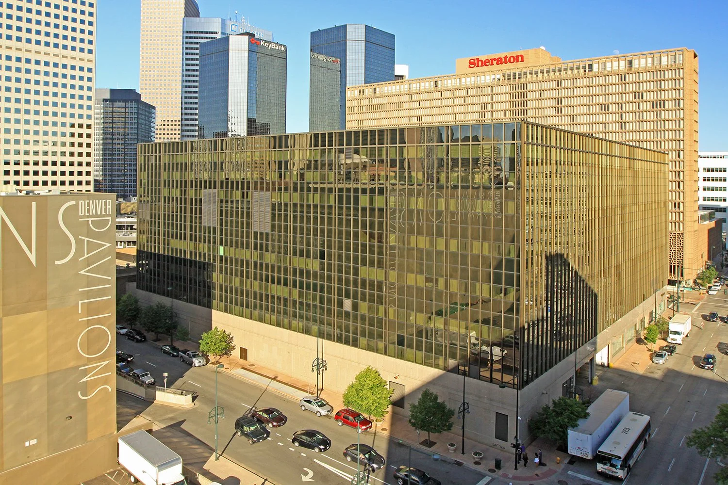A cityscape of  the Sheraton Downtown Denver hotel in the background and the Denver Center for the Performing Arts on the left side of the image.