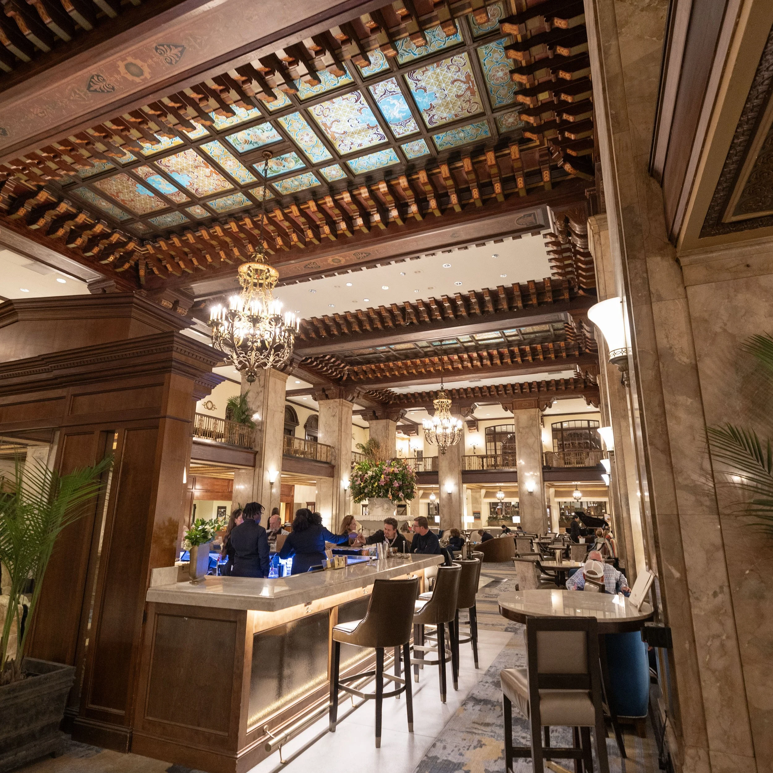 Interior of a hotel lobby or upscale restaurant with high ornate ceilings, chandeliers, marble columns. Peabody Hotel Memphis.