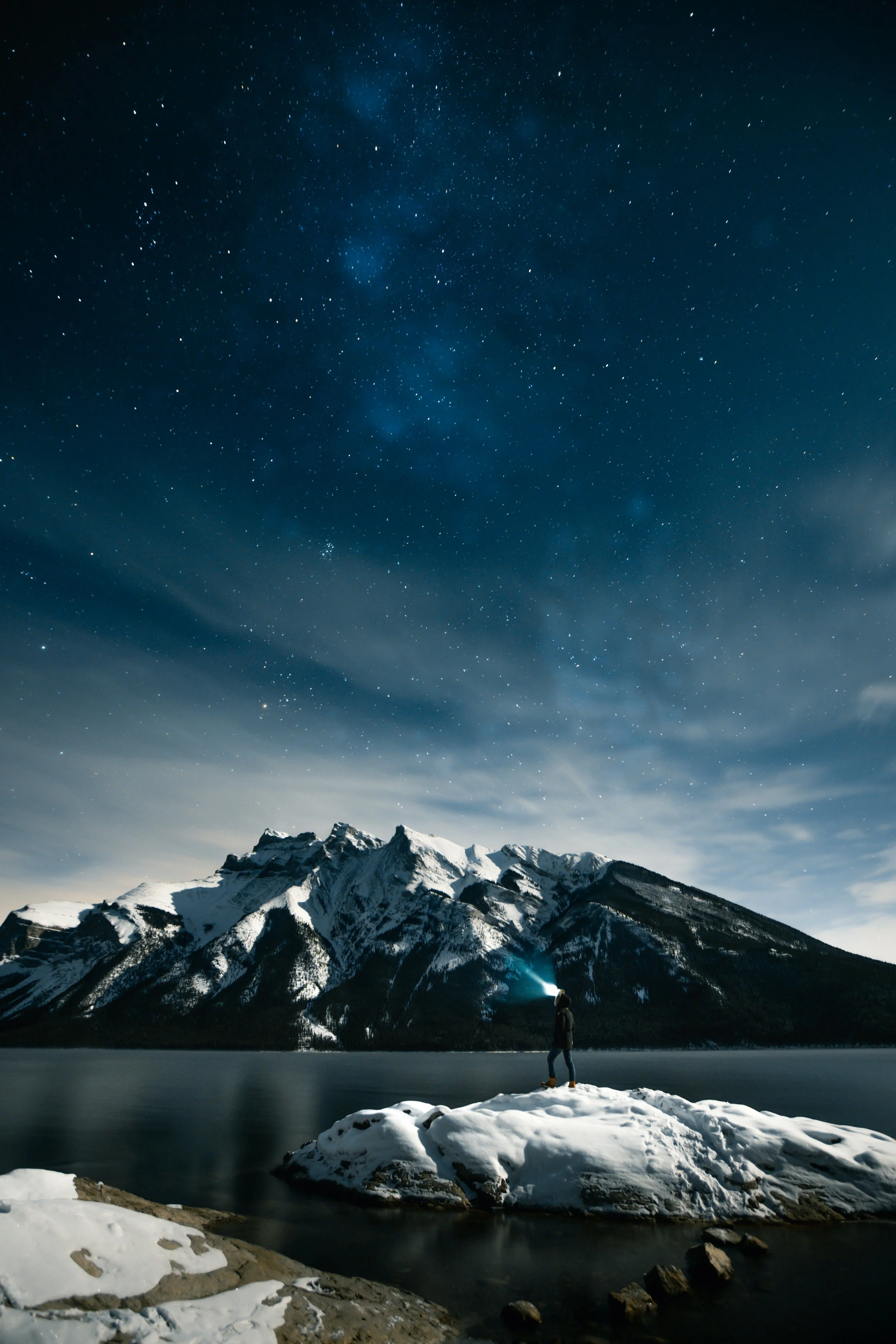 Man on rocks in the mountains symbolizing the searching the unseen or spiritual realms