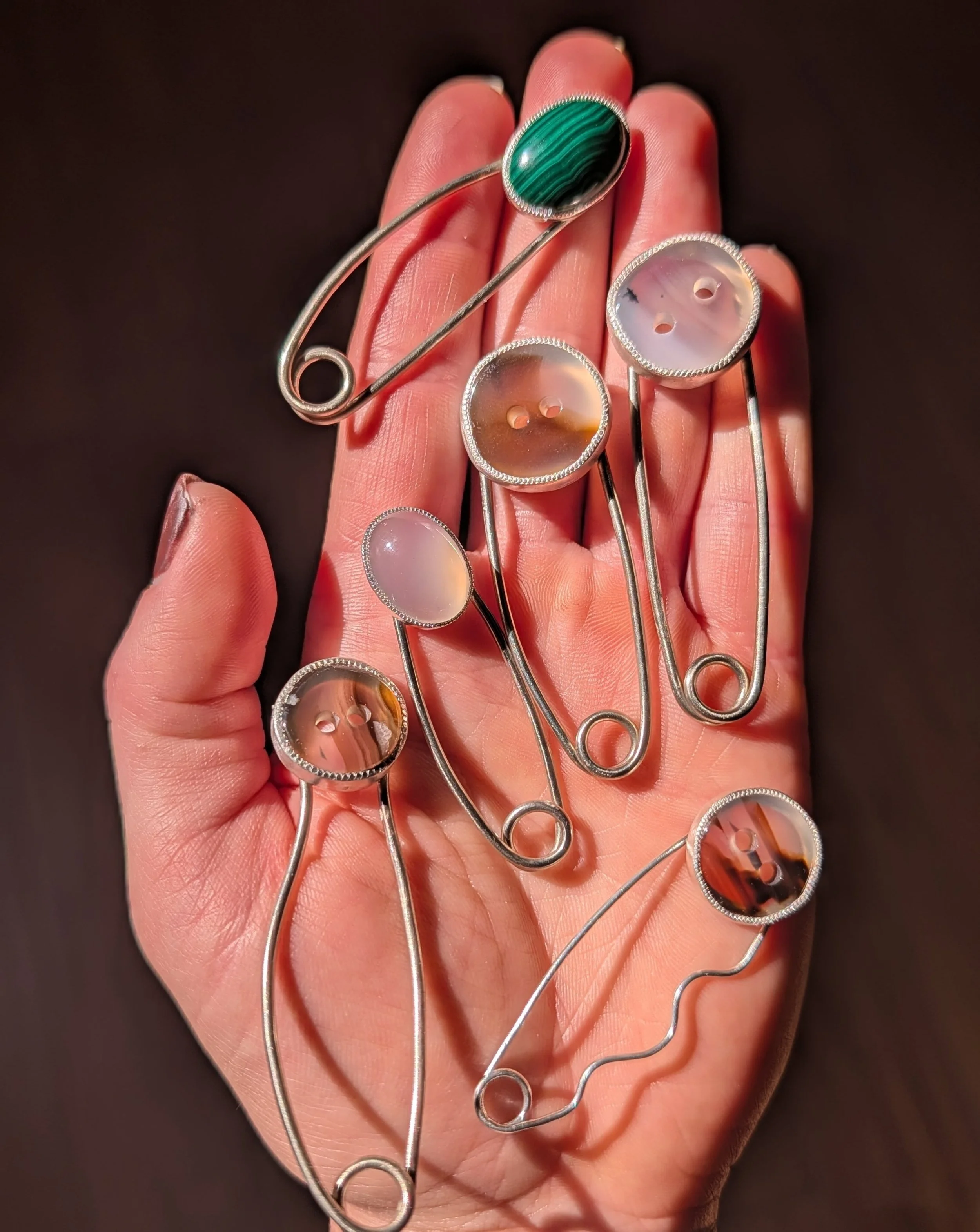 A fun diversion between customs and waiting for orders. Montana agate button, chalcedony and malachite safety pins. Pins, charms, keychains, whatever. DM for deets 👀

#safetypin #handmade #jewelrygram #slowfashion ##ootd