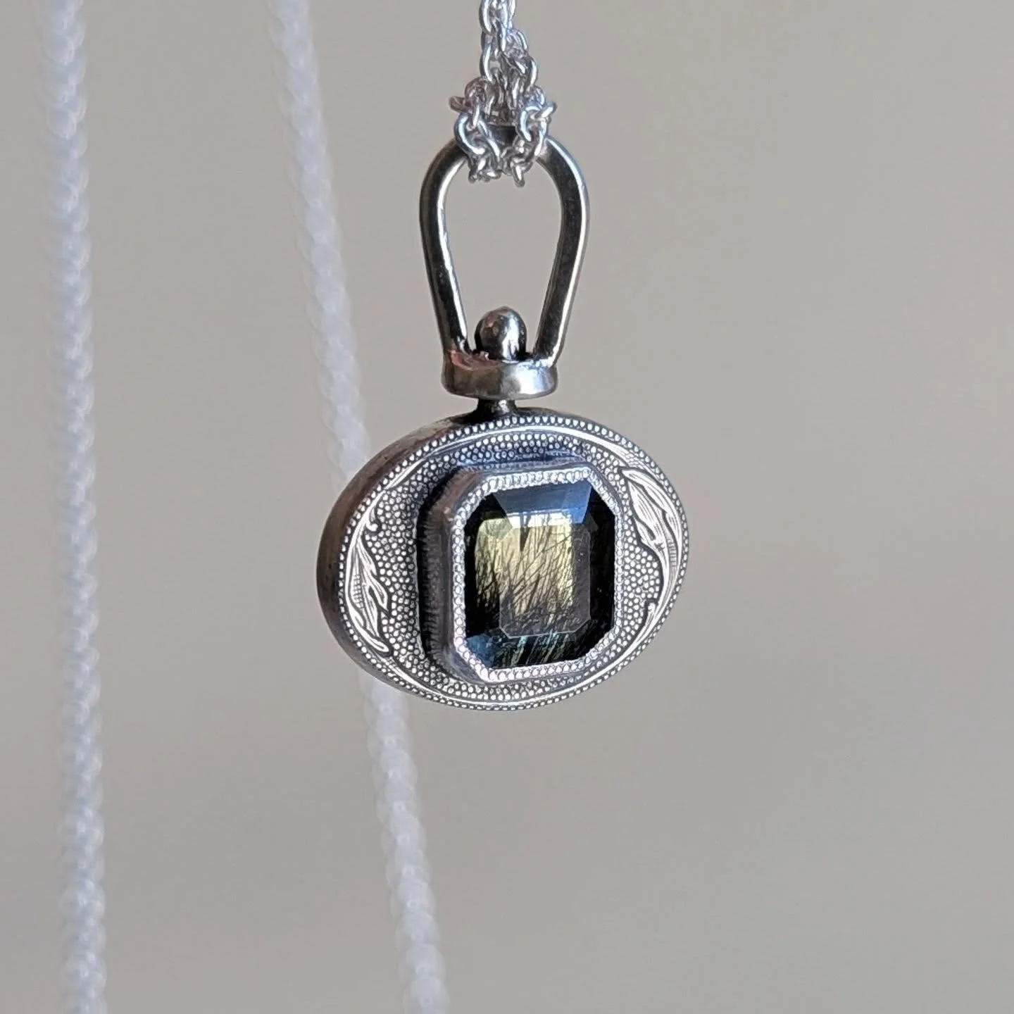 Across cultures the still, prayer-like posture of the praying mantis represents piety and patience. Hand engraved silver pendant, ludwigite in peridot bracket by mirror polished white gold. One of a kind, hand fabricated. Website update actually comi